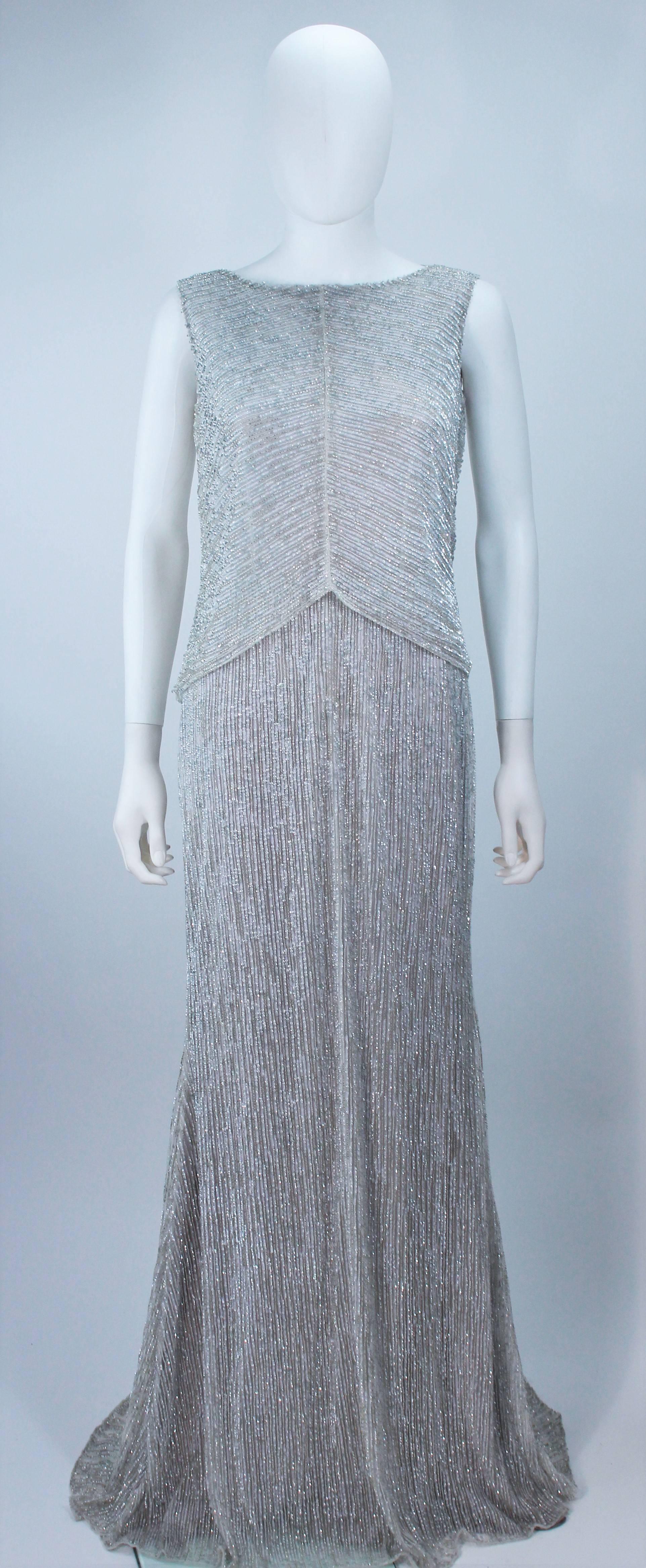 This Escada design is available for viewing at our Beverly Hills Boutique. We offer a large selection of evening gowns and luxury garments. 

 This gown is composed of a silver beaded silk. Features a draped back with center back zipper closure.