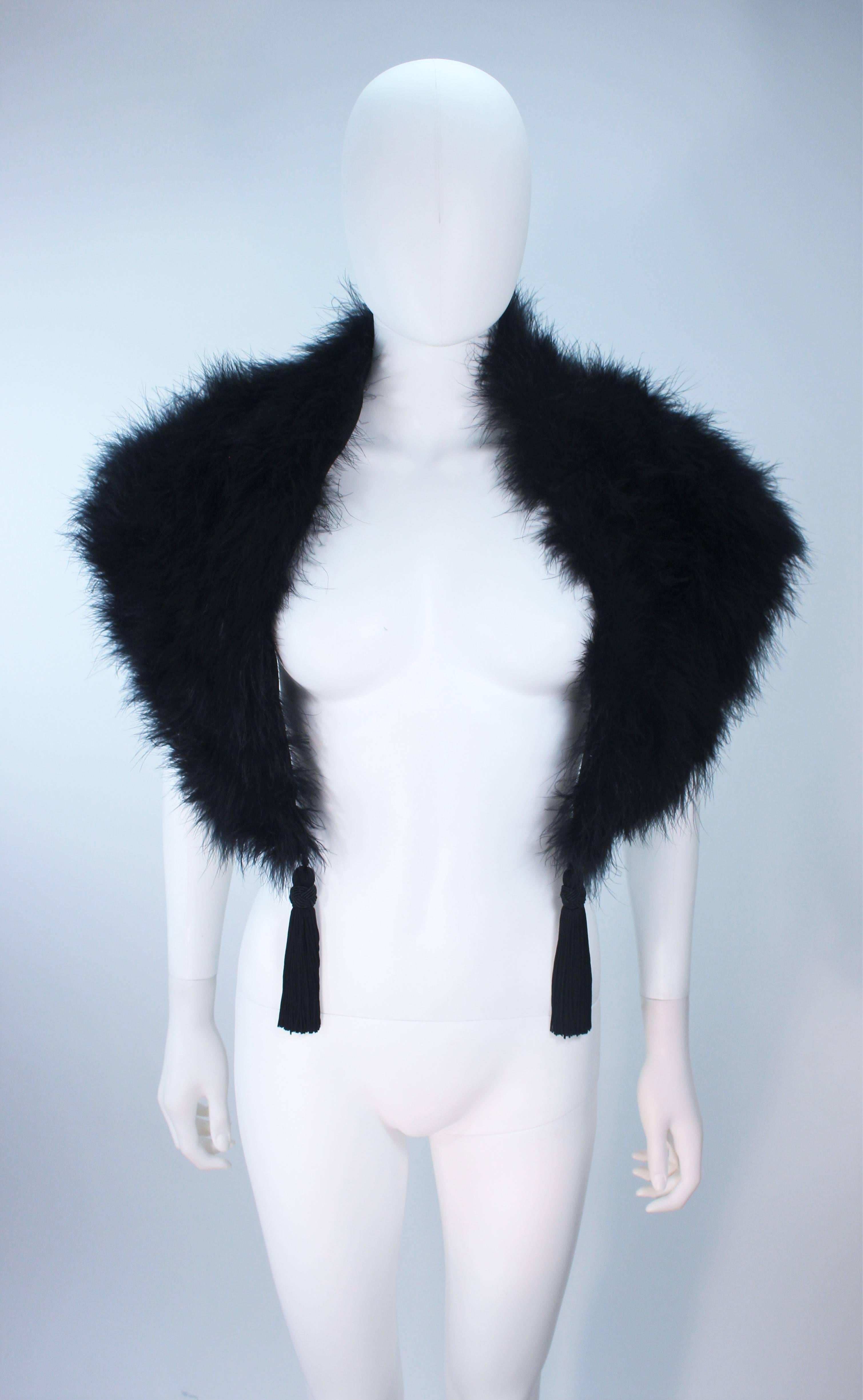 This Elizabeth Mason Couture Marabou  garment is composed of a supple marabou in a stunning black hue. Features a hook and eye closure with center front tassels. Can be worn around the shoulders or as a collar for any size. Designed in Beverly