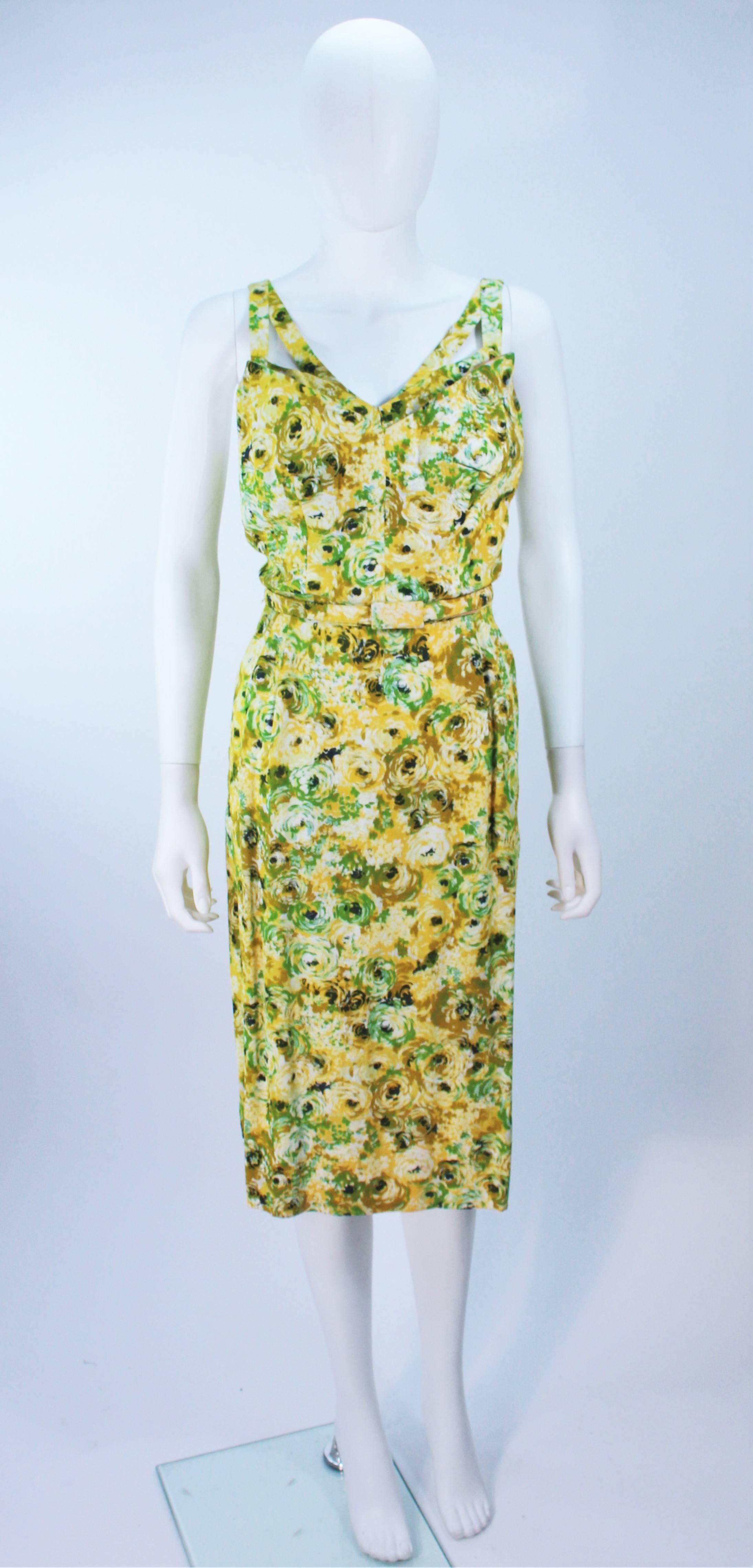  This ensemble is composed of a watercolor floral pattern in yellow and green hues. The dress features a pointed double bust design with belt and center back zipper closure. The coat has an open style with side slits. In excellent vintage