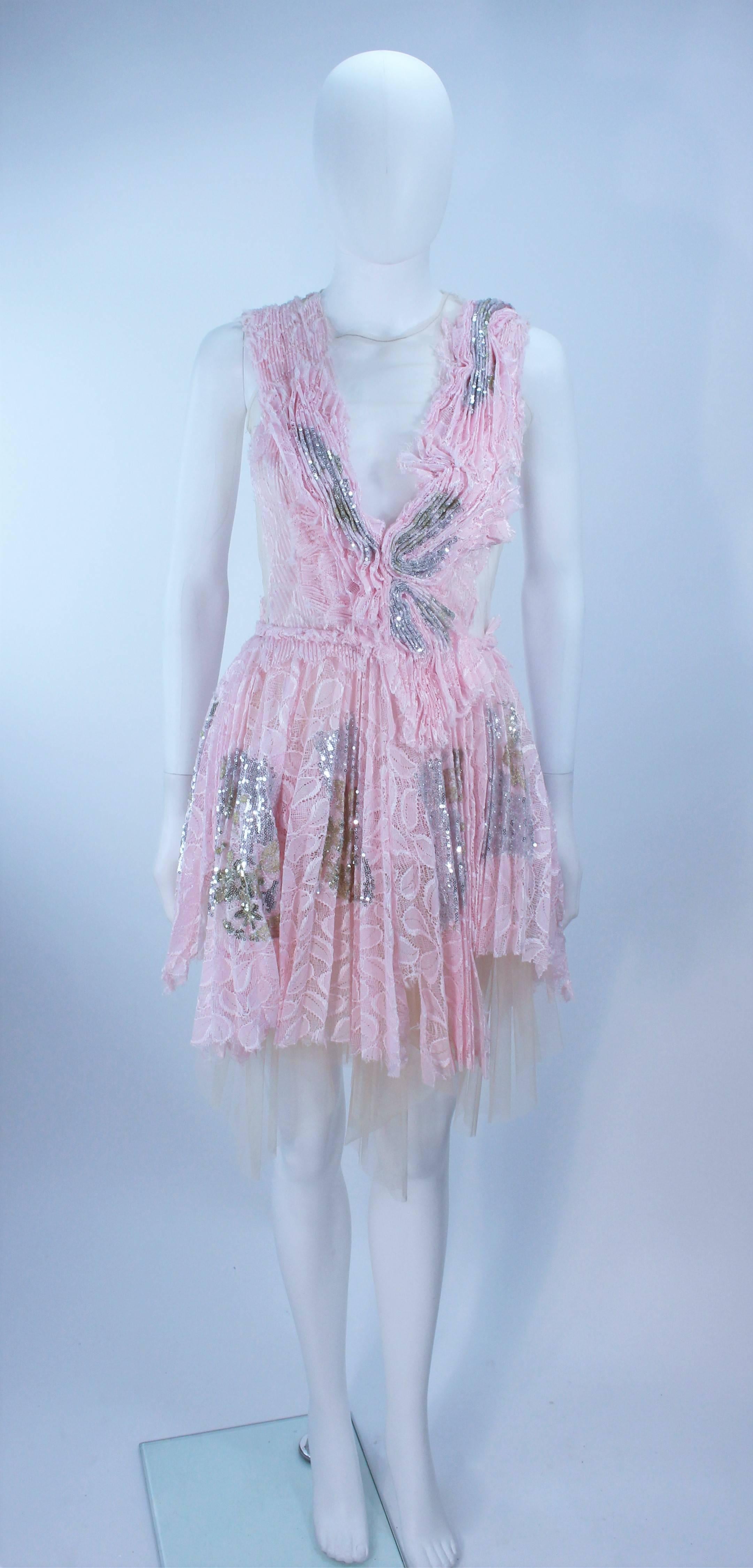 This Morales cocktail dress is composed of a nude sheer mesh with a pink pleated lace applique and sequin accents. There is a center back zipper closure. In excellent pre-owned condition, minimally worn, possibly new.

  **Please cross-reference