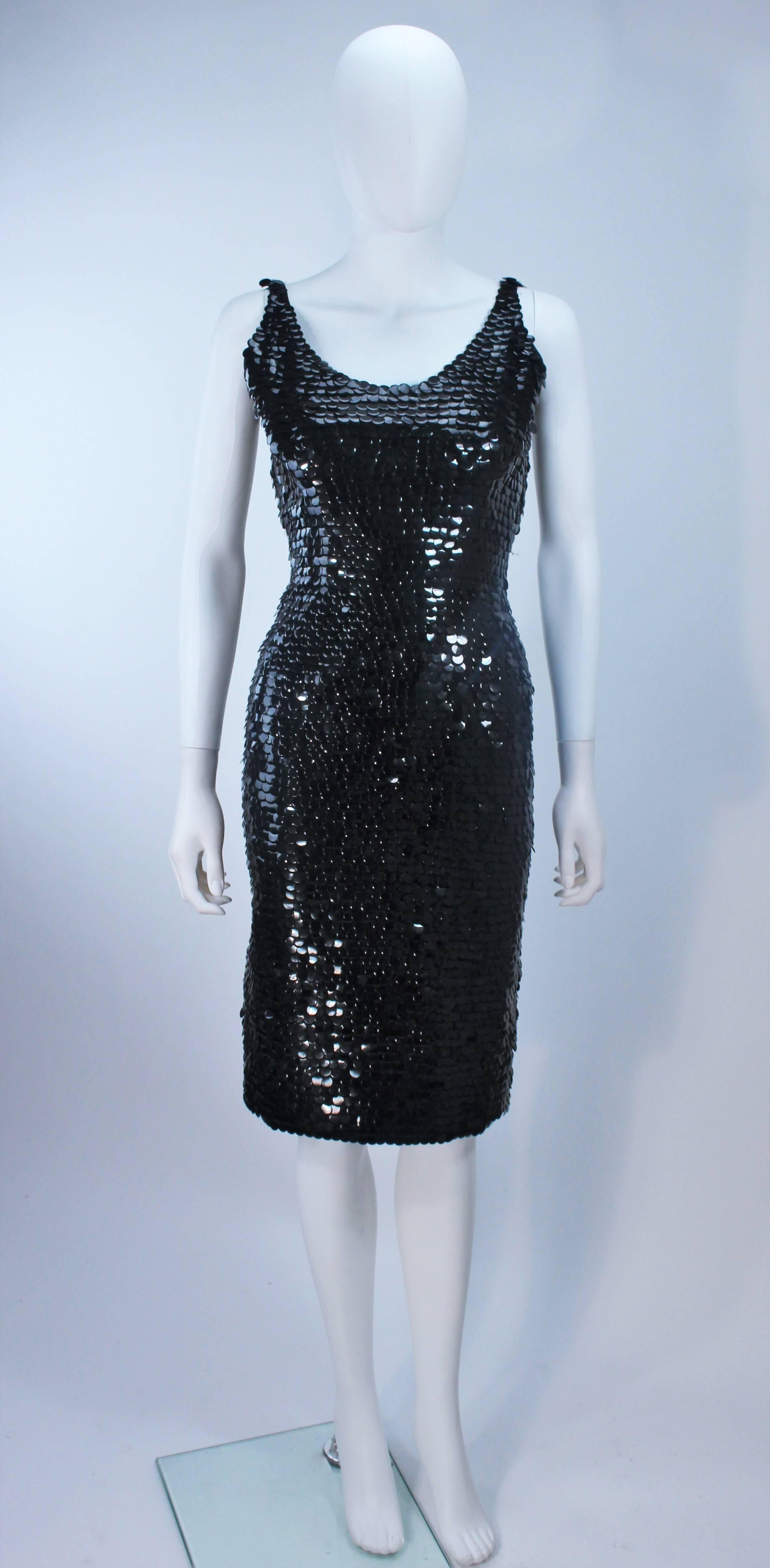 This fabulous fully HAND-BEADED cocktail dress is composed of large, dime sized black flat plastic sequins. Features a classic 'Wiggle Dress' style with a center back zipper closure. 
The cocktail is in excellent vintage condition.

  **Please