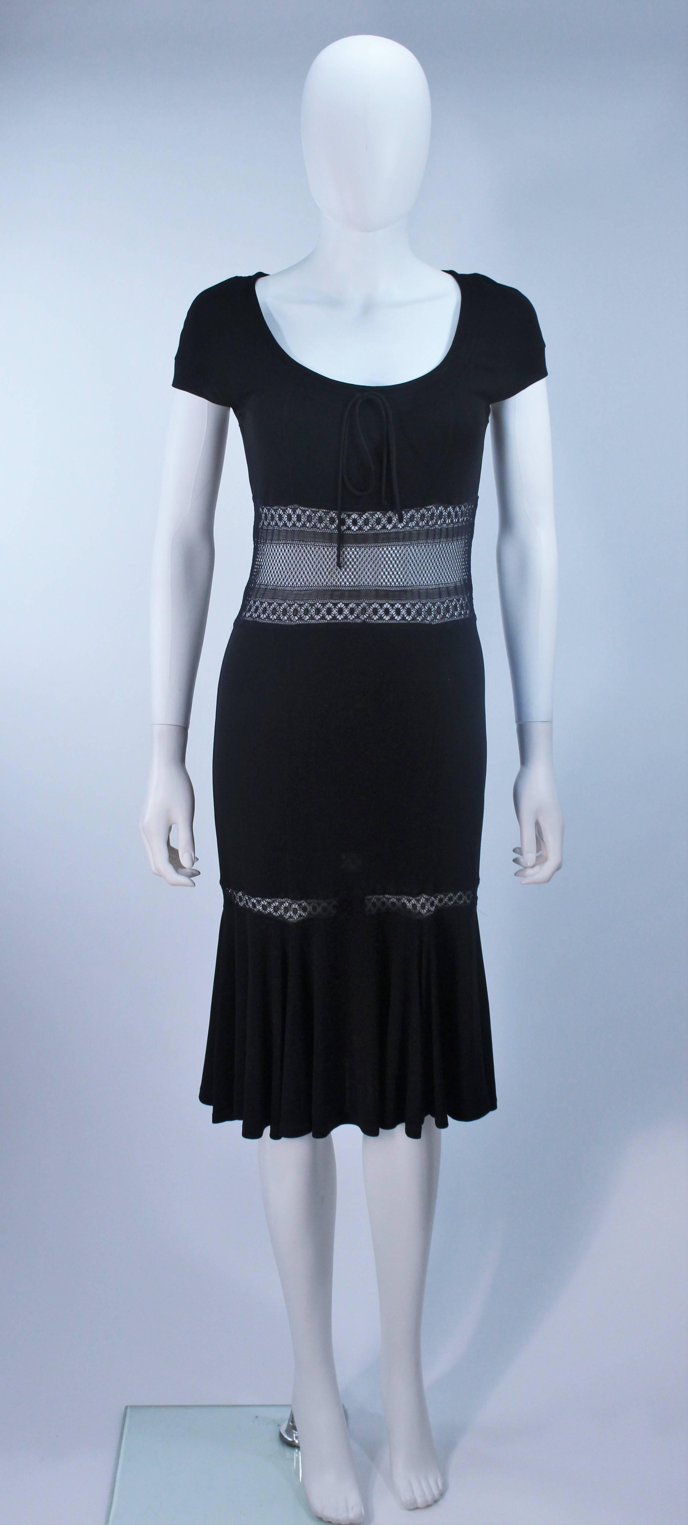 This Blumarine  dress is composed of a black stretch jersey with lace insets and center front tie. Features a form fitting design with a flare hem. In excellent vintage condition.

  **Please cross-reference measurements for personal accuracy.