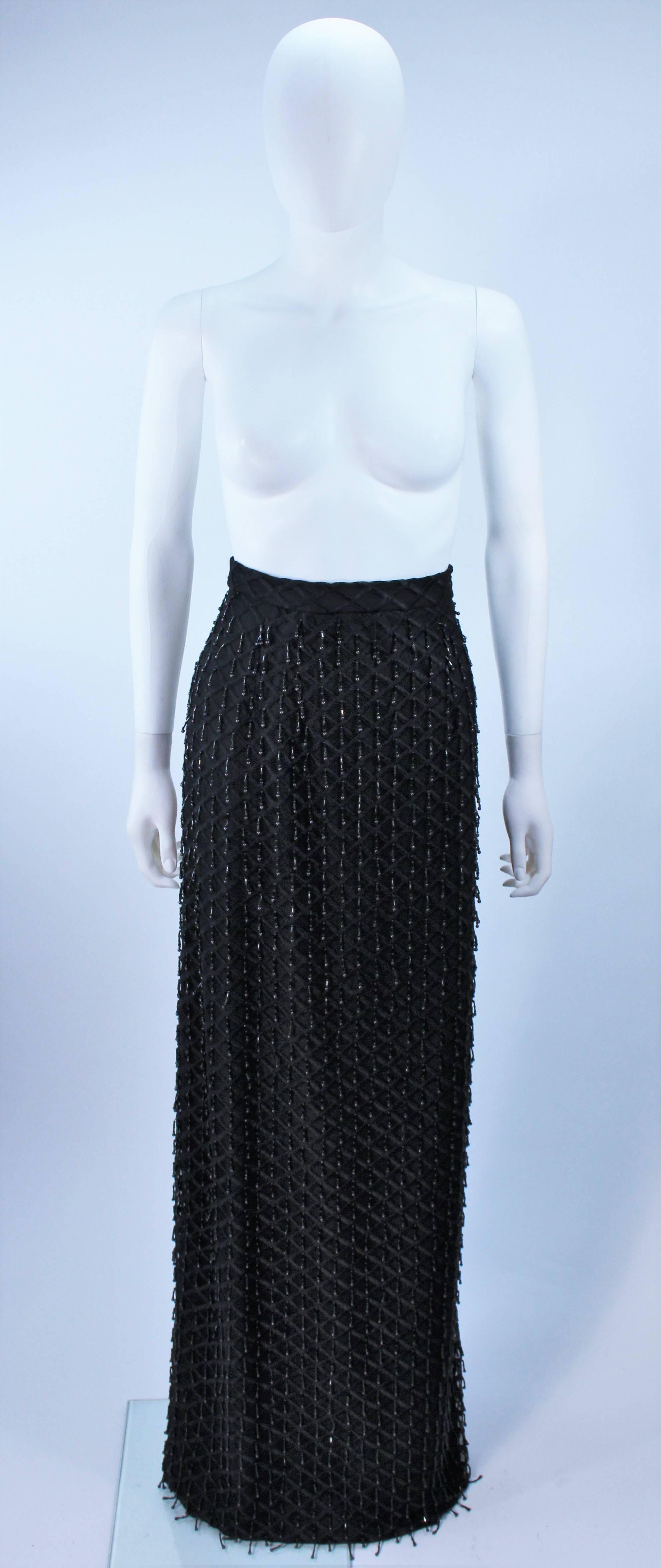  This skirt is composed of a beaded black lace fabric with a fringe style beading throughout. There is a center back zipper. In excellent vintage condition/

  **Please cross-reference measurements for personal accuracy. Size in description box is