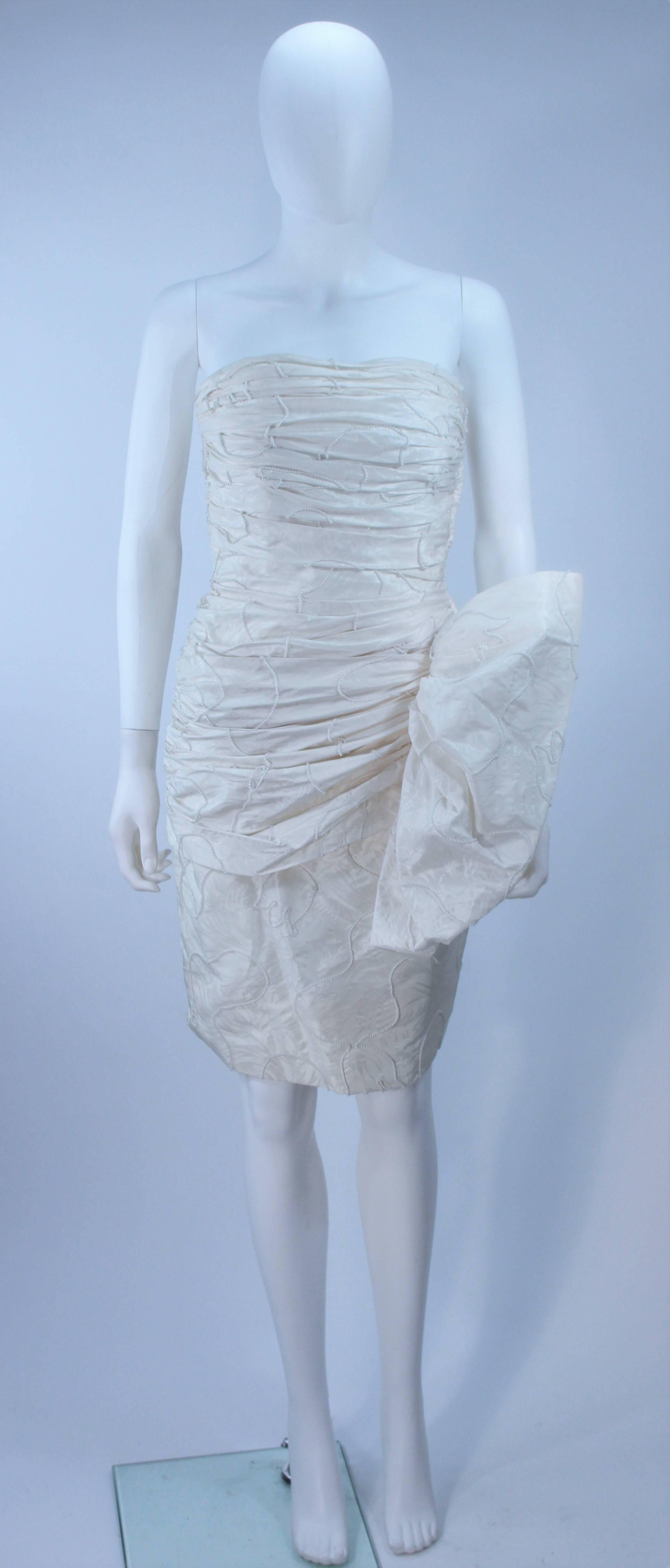 This Vicky Tiel  dress is composed of a white pearl accent beaded fabric, with ruching and gathers. There is a side zipper closure. In excellent vintage condition.

  **Please cross-reference measurements for personal accuracy. 

Measures
