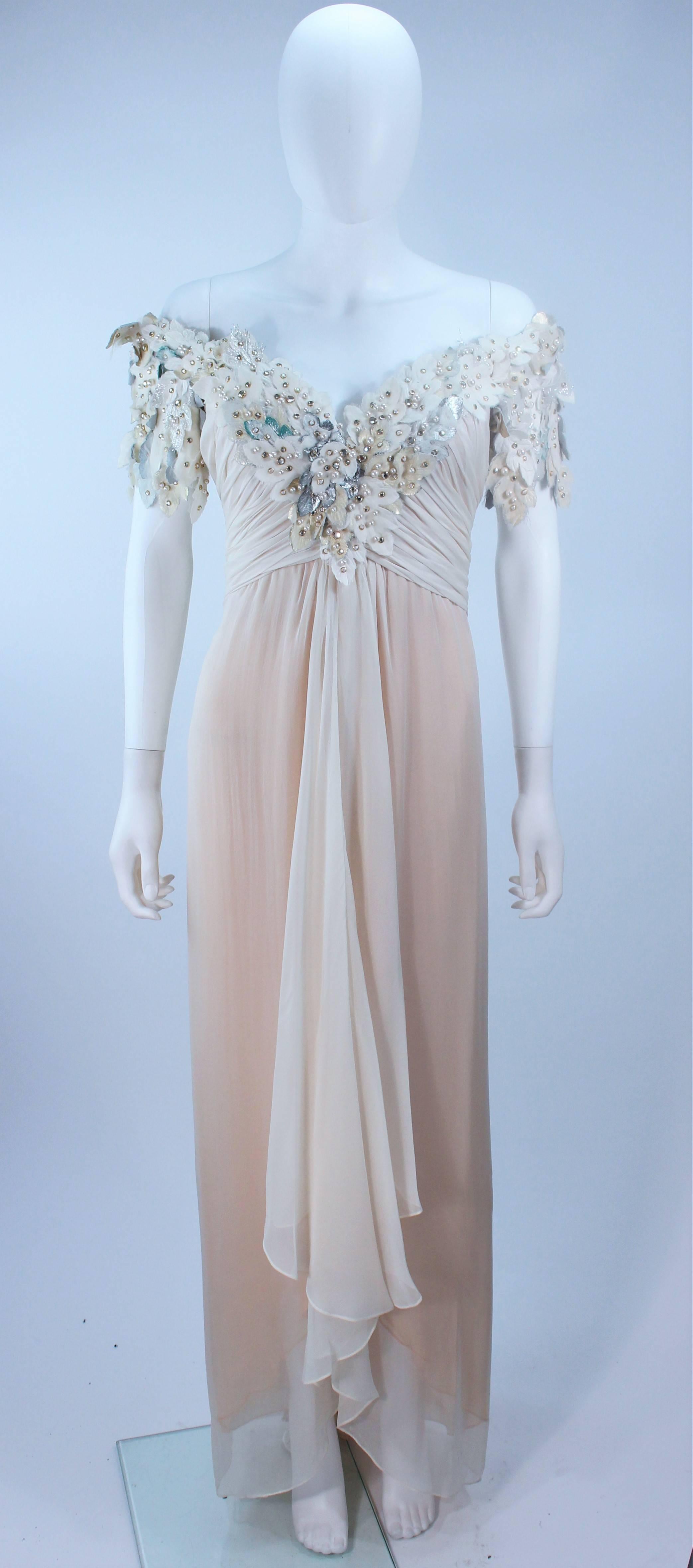 This Bob Mackie gown is composed of nude and off white silk chiffon with a multi textured flower applique with rhinestones. There is a center back zipper closure, with boned bustier interior for support. In excellent vintage condition.

  **Please