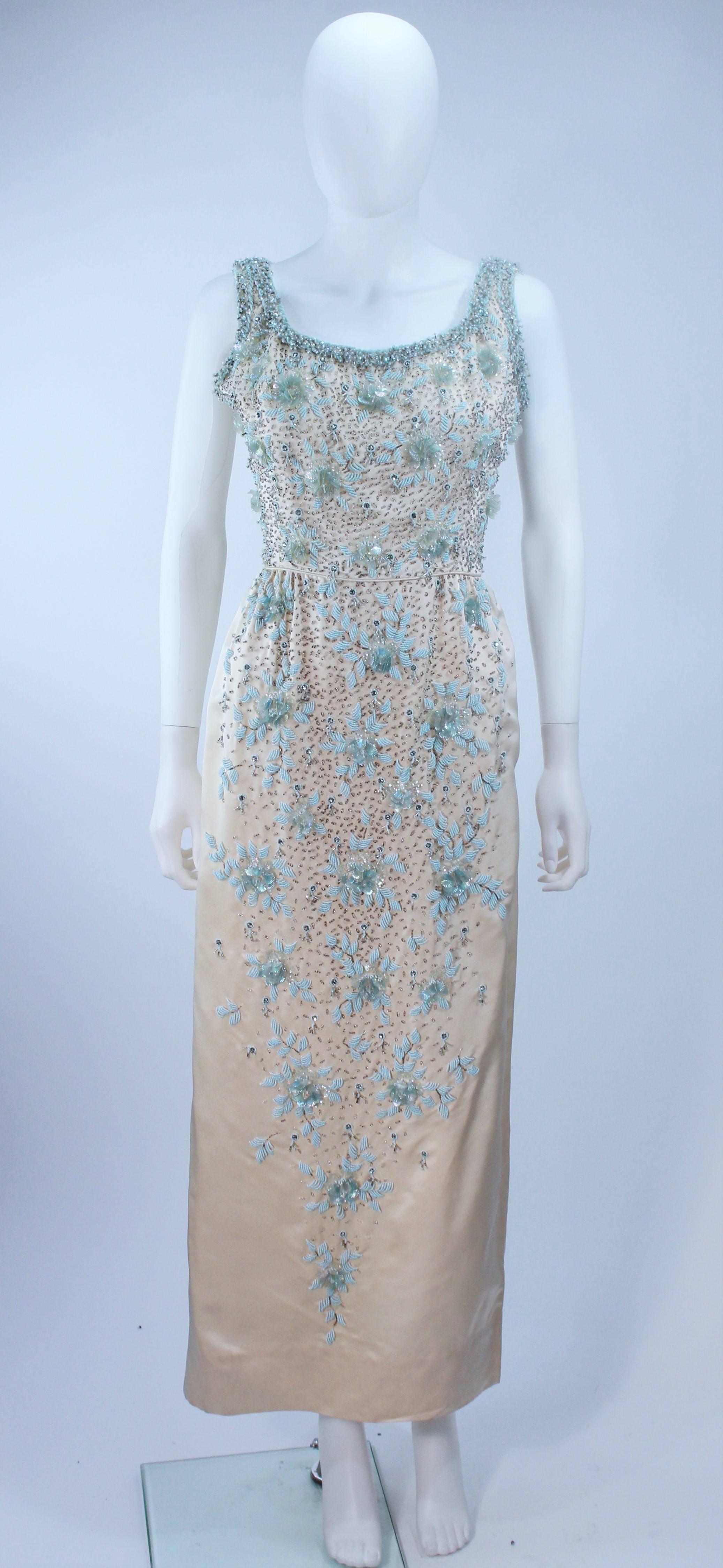  This gown is composed of a creme silk with blue floral relief beading with silver. This classic style has a center back zipper closure. In excellent vintage condition.

  **Please cross-reference measurements for personal accuracy. 

Measures