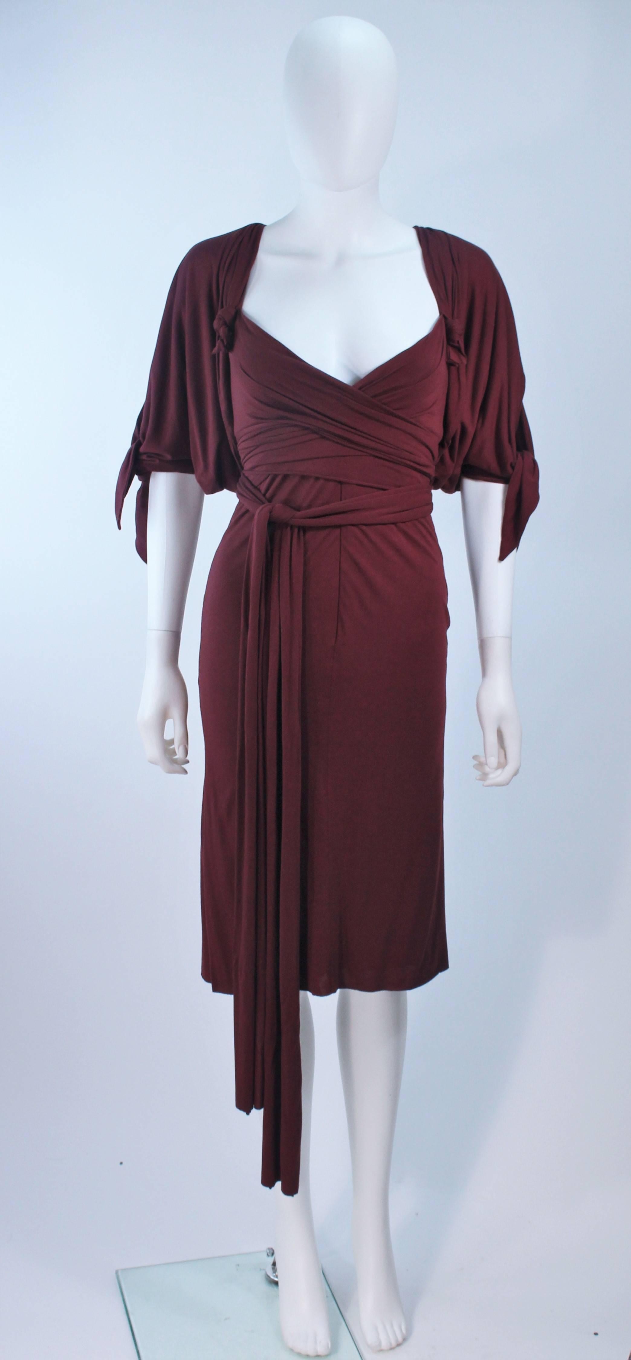 This Elizabeth Mason Couture dress  features a a draped cocktail length design. There is a center front zipper and interior boned foundation. The dress offers a waist tie which can be styled in a variety of fashions. Made in Beverly Hills. 

 The