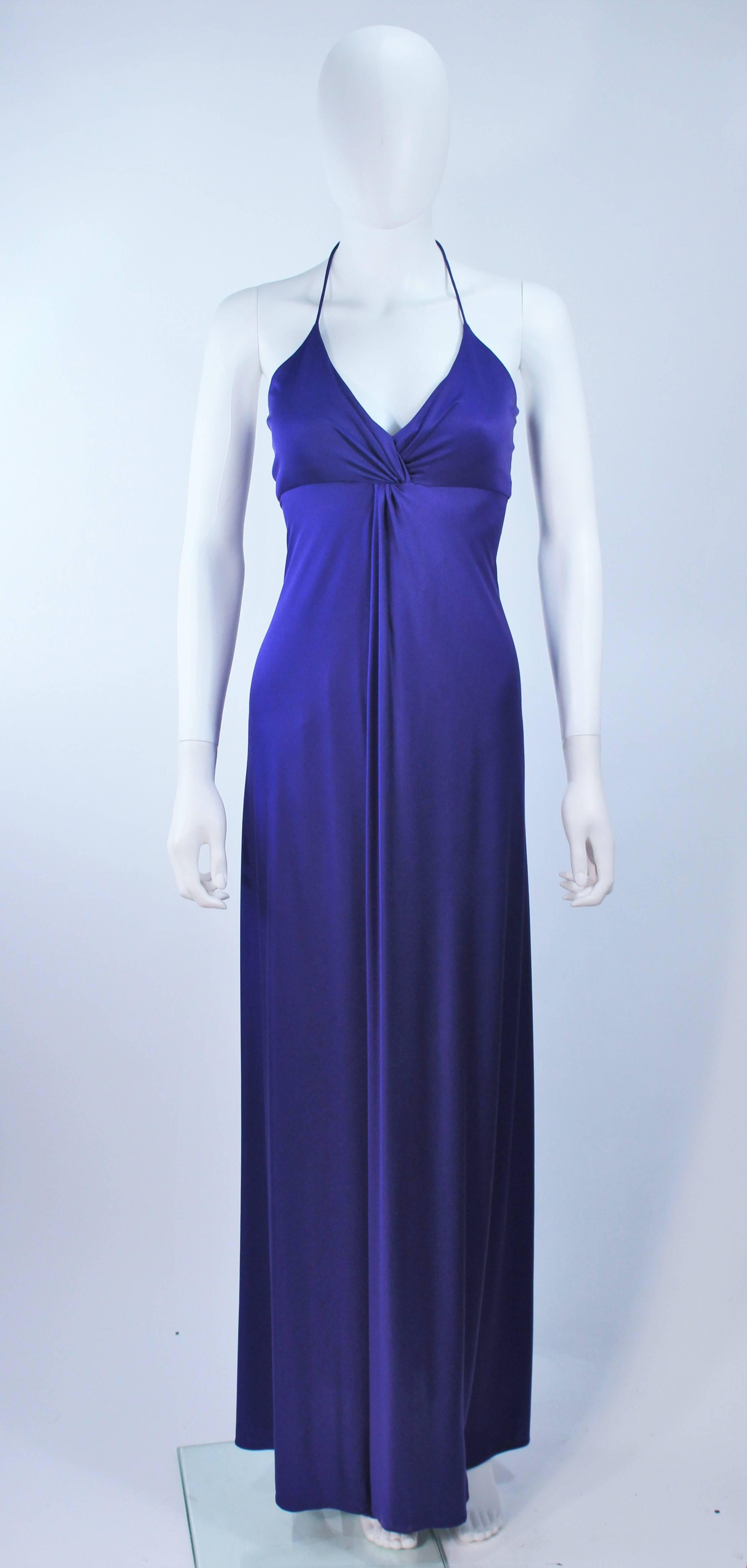 This Elizabeth Mason Couture  gown is composed of a purple silk jersey and features a draped design. There is a halter style neckline. This effortlessly chic gown can be styled in a variety of fashions. Made in Beverly Hills. 

 The gown may be