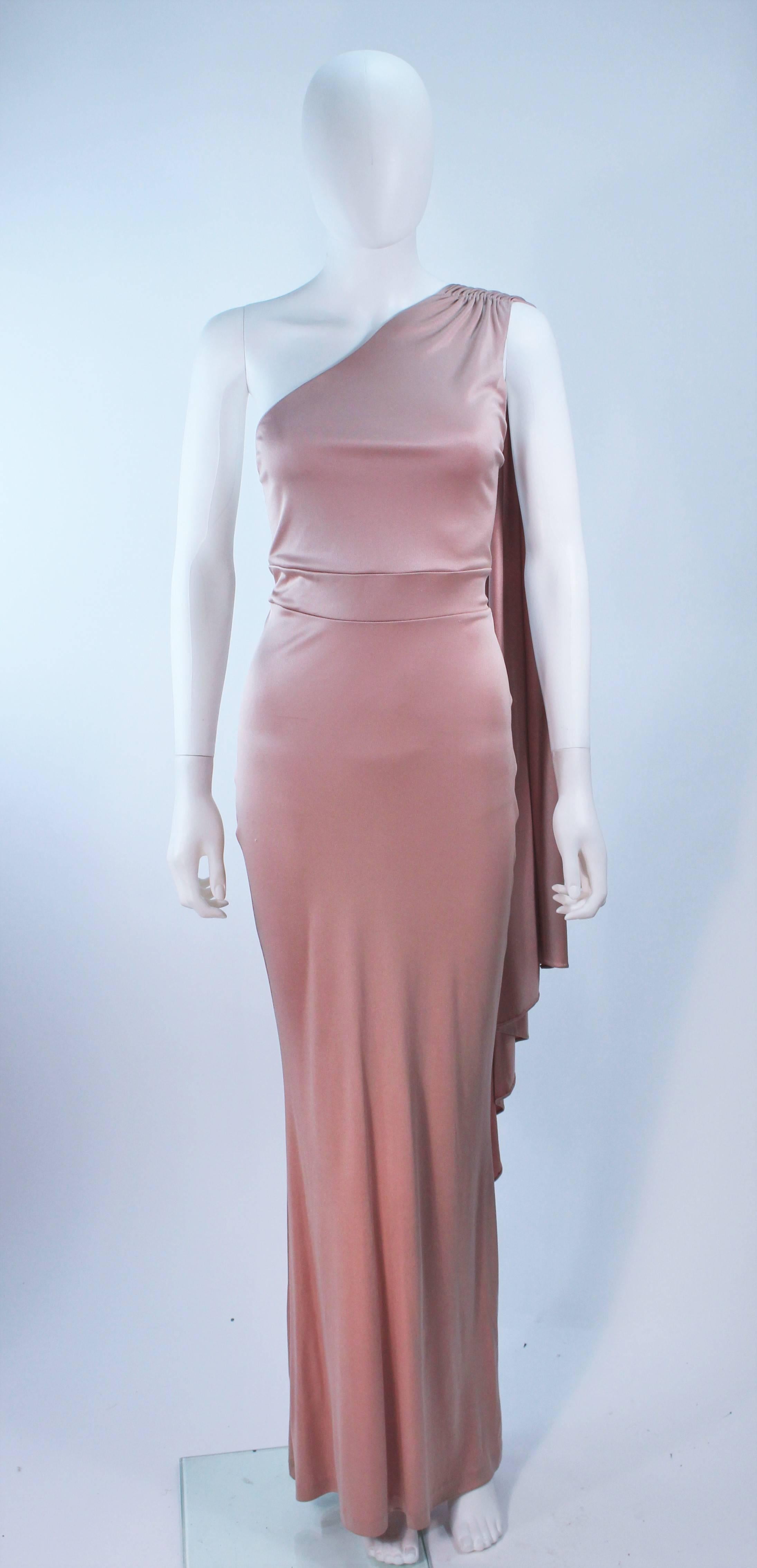 This Elizabeth Mason Couture gown is composed of a pink mauve silk jersey ('Blush' hue) and features a draped asymmetrical one shoulder design. This effortlessly chic gown can be styled in a variety of fashions. Made in Beverly Hills. 

 The gown