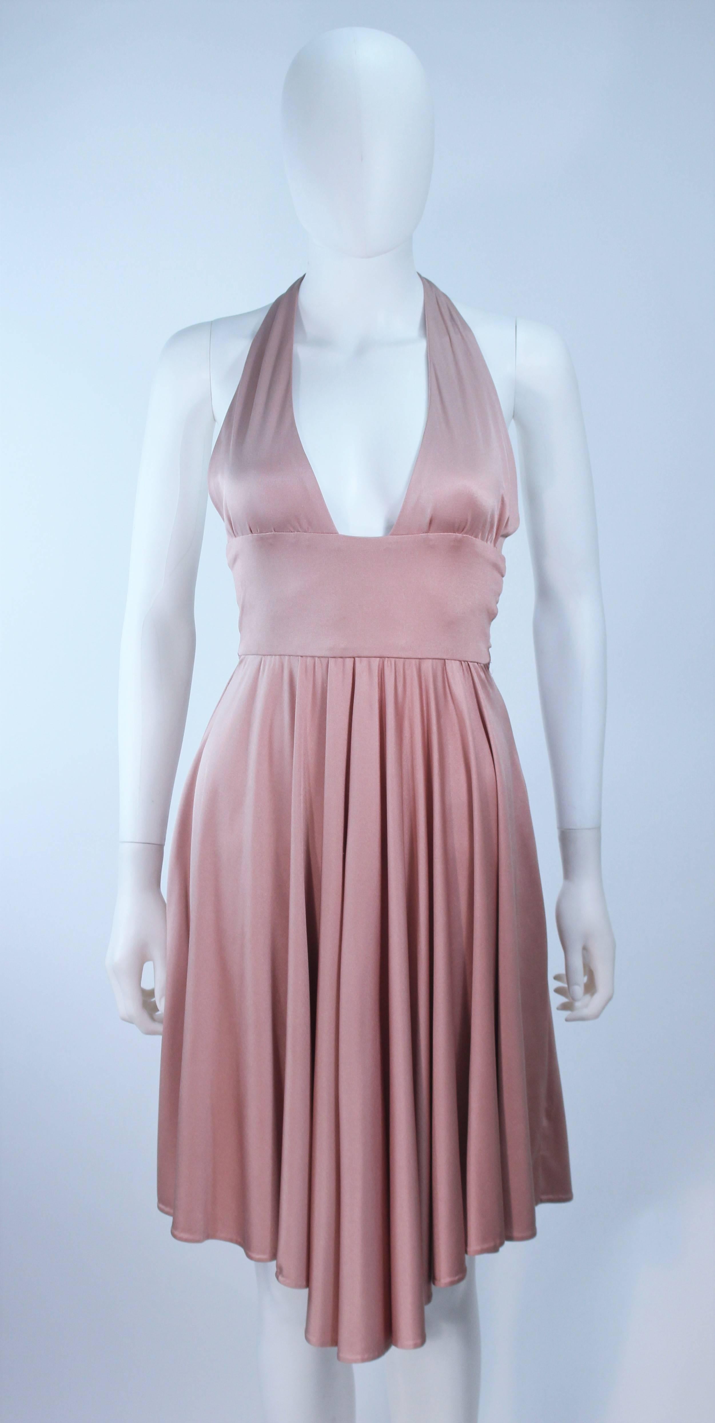 This Elizabeth Mason Couture  gown is composed of a pink mauve silk jersey ('Blush' hue) and features a draped design. This halter style dress has a waist wrap. This effortlessly chic dress can be styled in a variety of fashions. Made in Beverly
