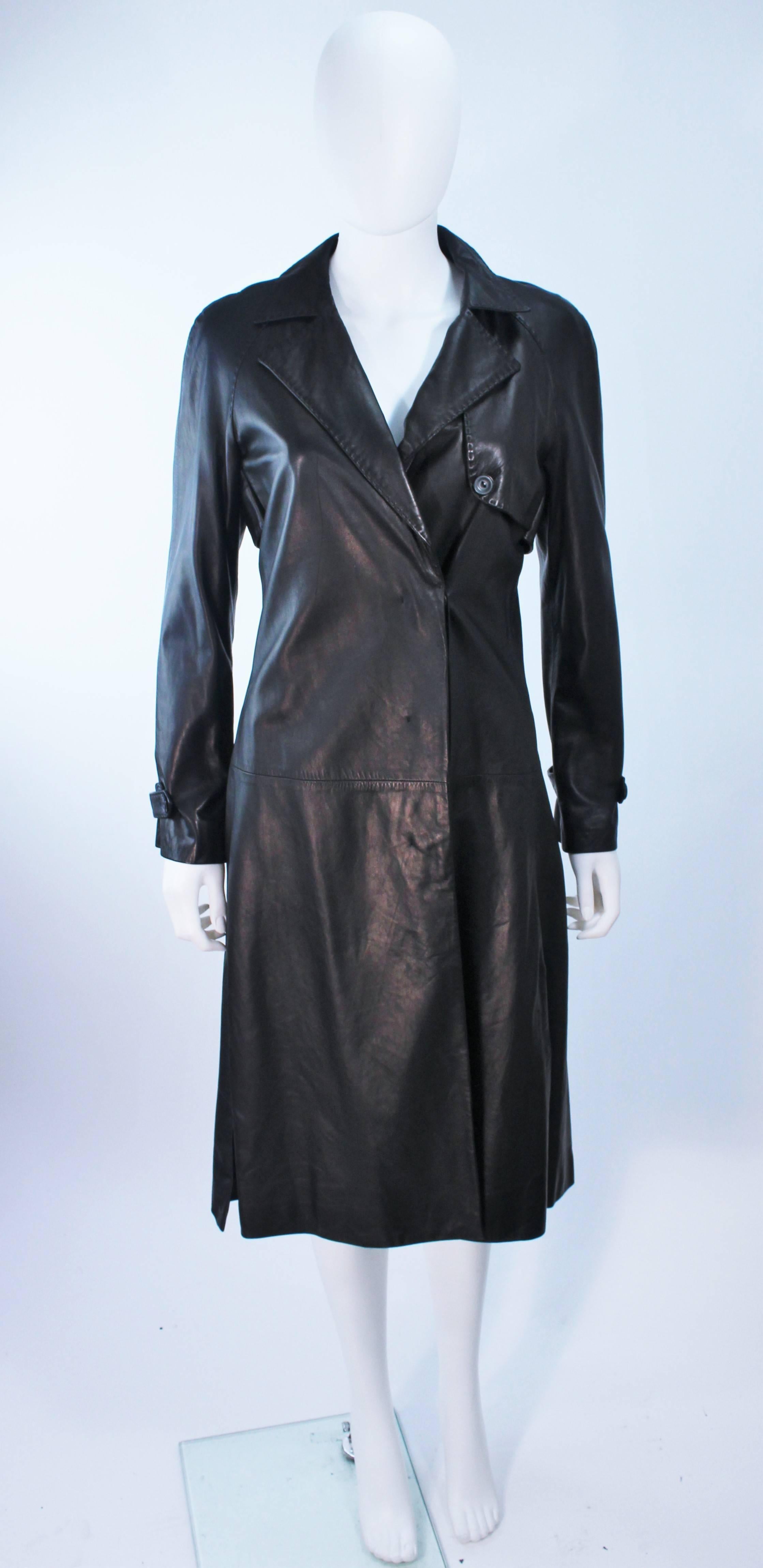This Alexander McQueen coat is composed of an extremely soft fine grade black leather. Features a trench style with center front button closure and pockets. Top-stitch collar detail as well. In great condition. Made in Italy.

  **Please