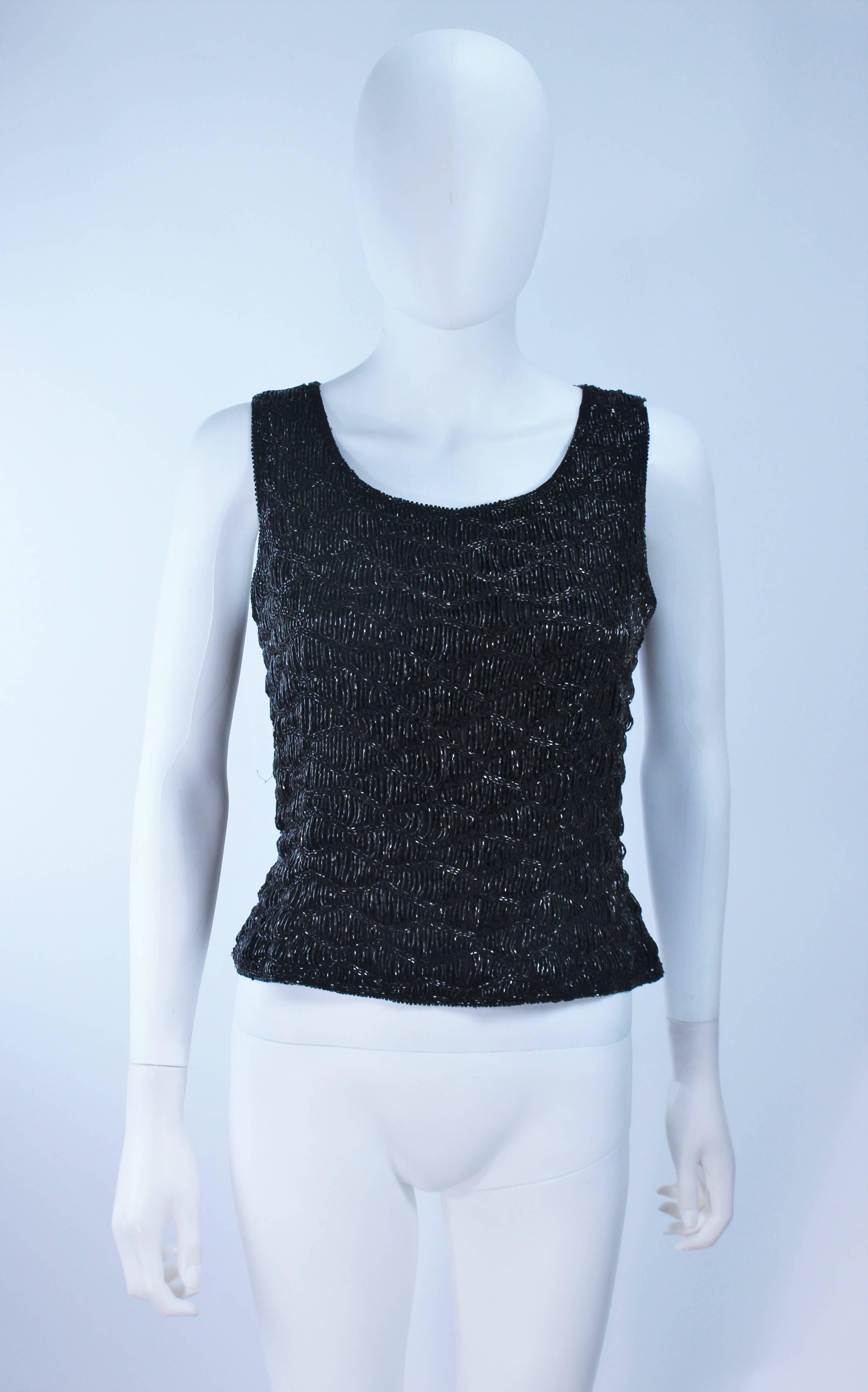  This handmade blouse is composed of a black silk with hand beading. Features a sleeveless style with a zipper closure. In excellent condition.

  **Please cross-reference measurements for personal accuracy. 

Measures (Approximately)
Length: