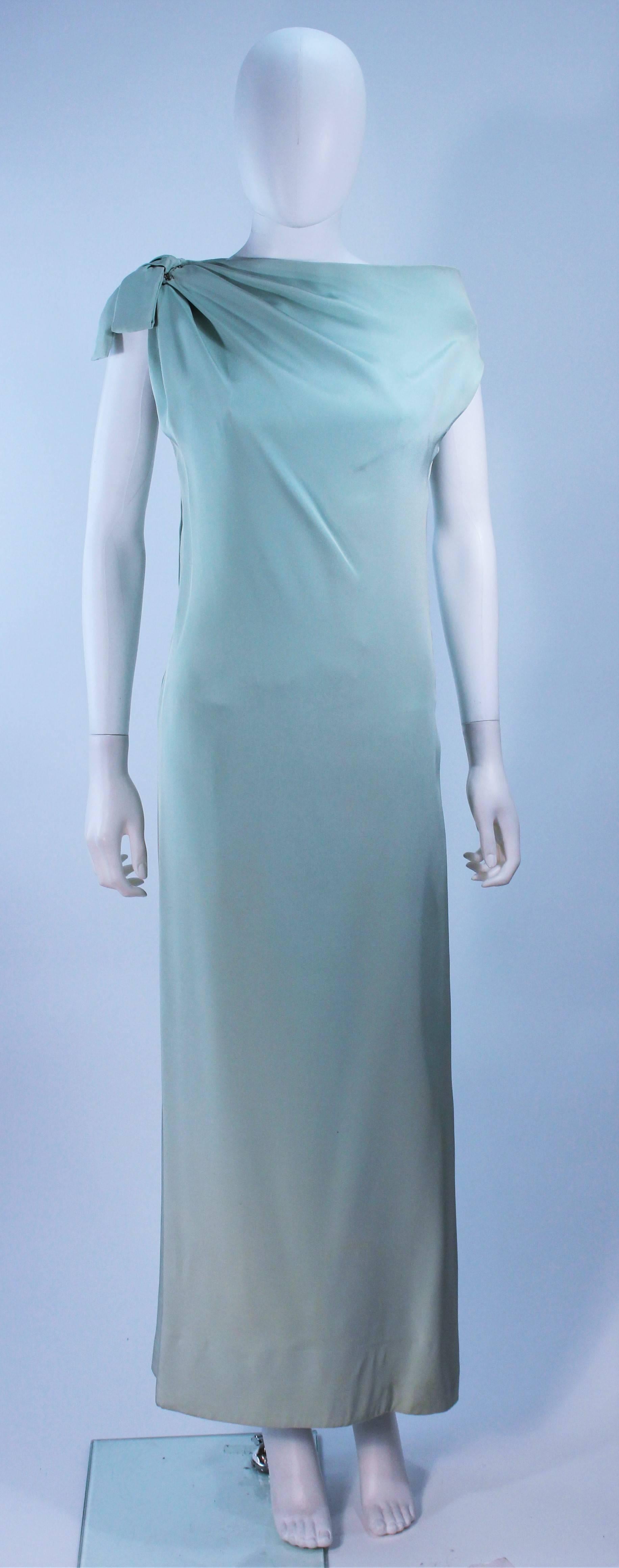 This Christian Dior  gown is composed of an aqua crepe silk with as silk satin slip. Features an asymmetrical design with a side zipper. In excellent vintage condition, there are some signs of wear due to age. 

  **Please cross-reference