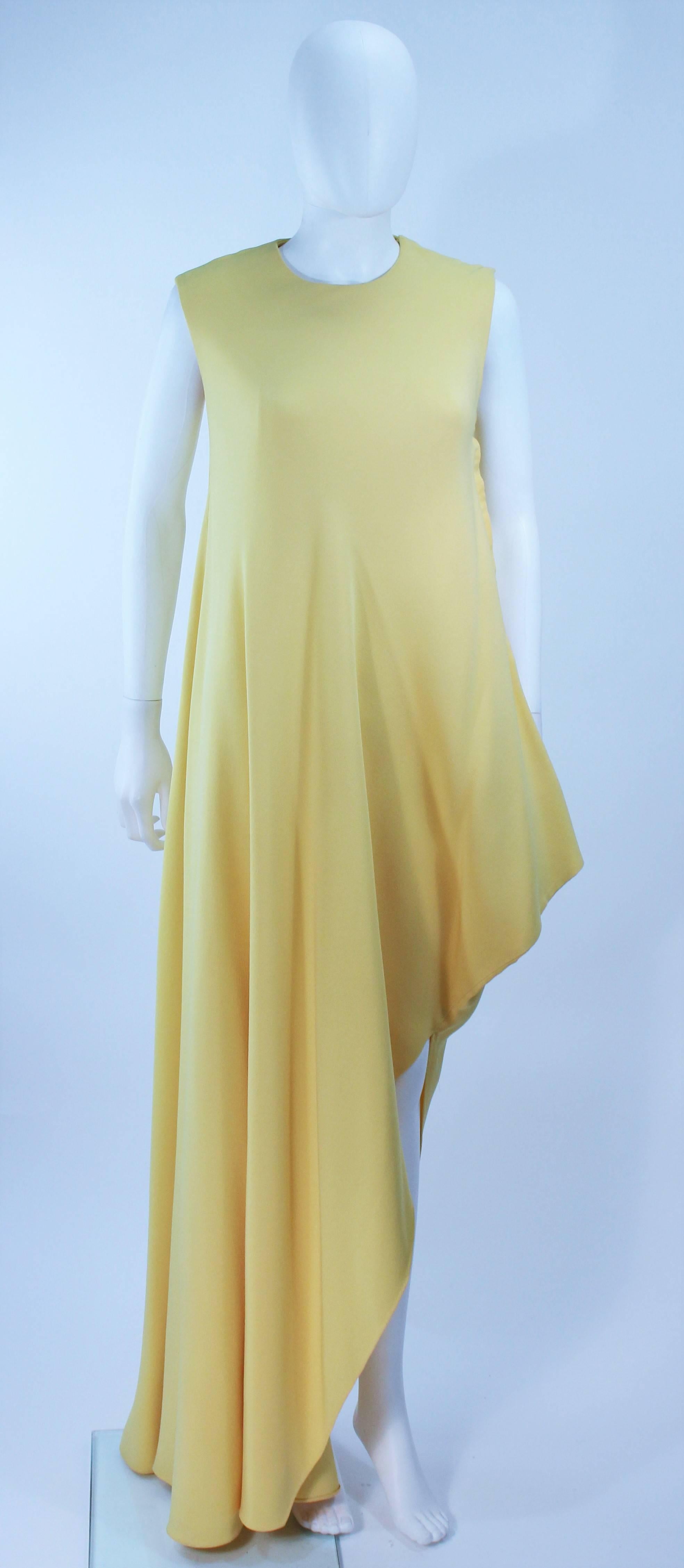 
 Dieses Kleid ist aus gelbem Seidenkrepp gefertigt. Asymmetrisches Design mit Schnappverschlüssen. In ausgezeichnetem Vintage-Zustand. 

  **Bitte vergleichen Sie die Maße für Ihre persönliche Genauigkeit. Die Größe im Beschreibungsfeld ist eine