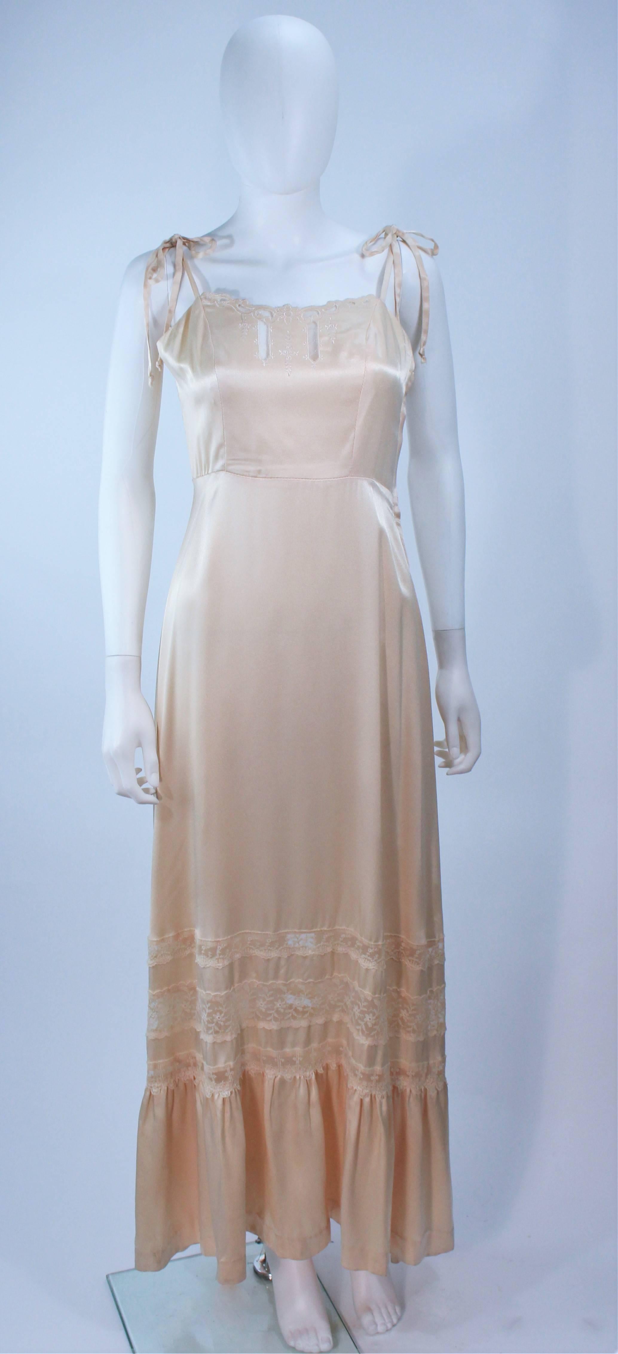 This Young Edwardian gown is composed of a off white yellow hued satin. Features a smocked back design with shoulder tie straps. There is a center back zipper closure. In great vintage condition, there is a pink discoloration mark (see photo).

 
