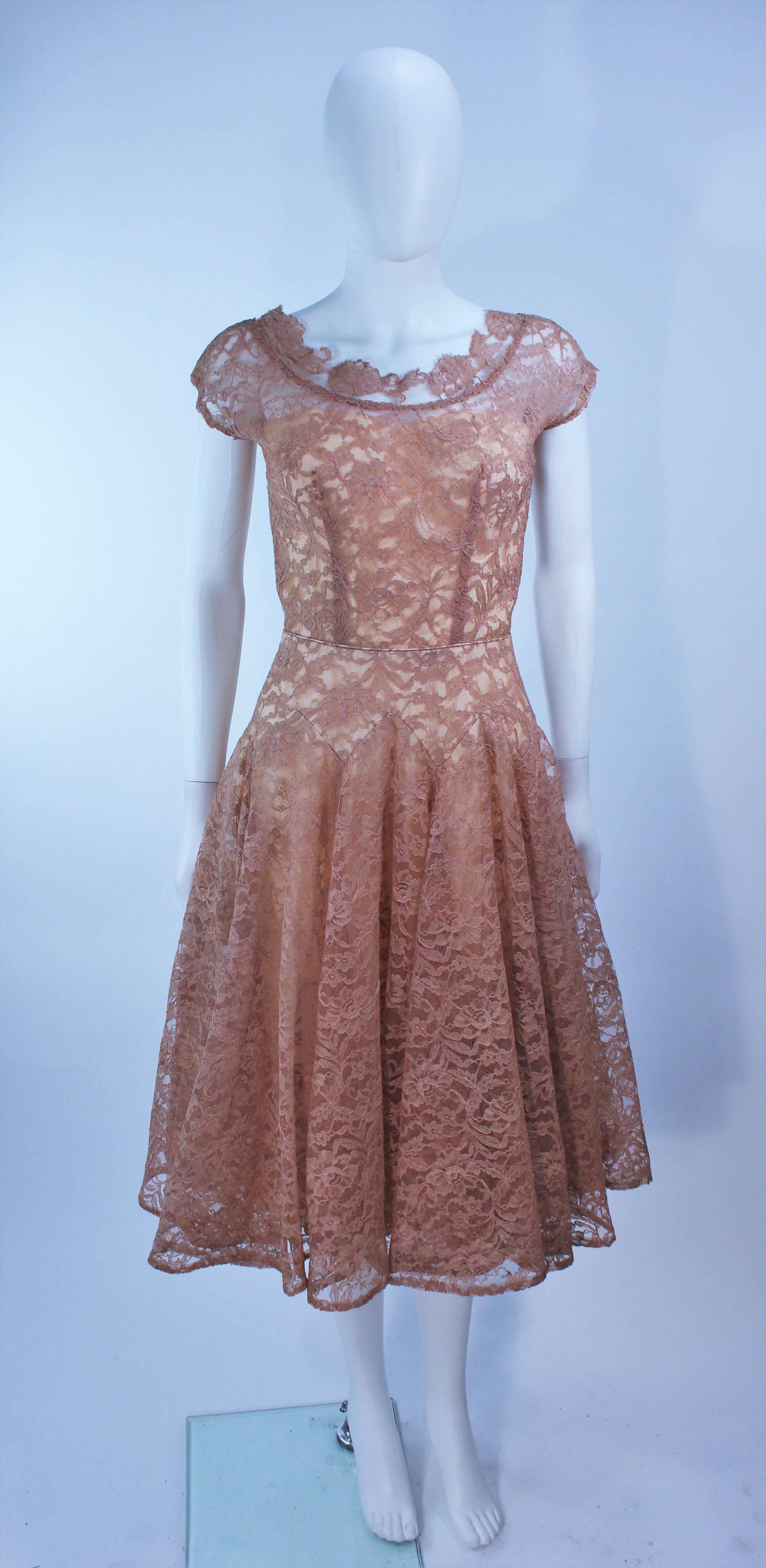  This cocktail dress is composed of a peach/beige hue lace with scalloped edges. Features a scalloped edge neckline and full skirt. There is a center back zipper closure. In great vintage condition.

  **Please cross-reference measurements for