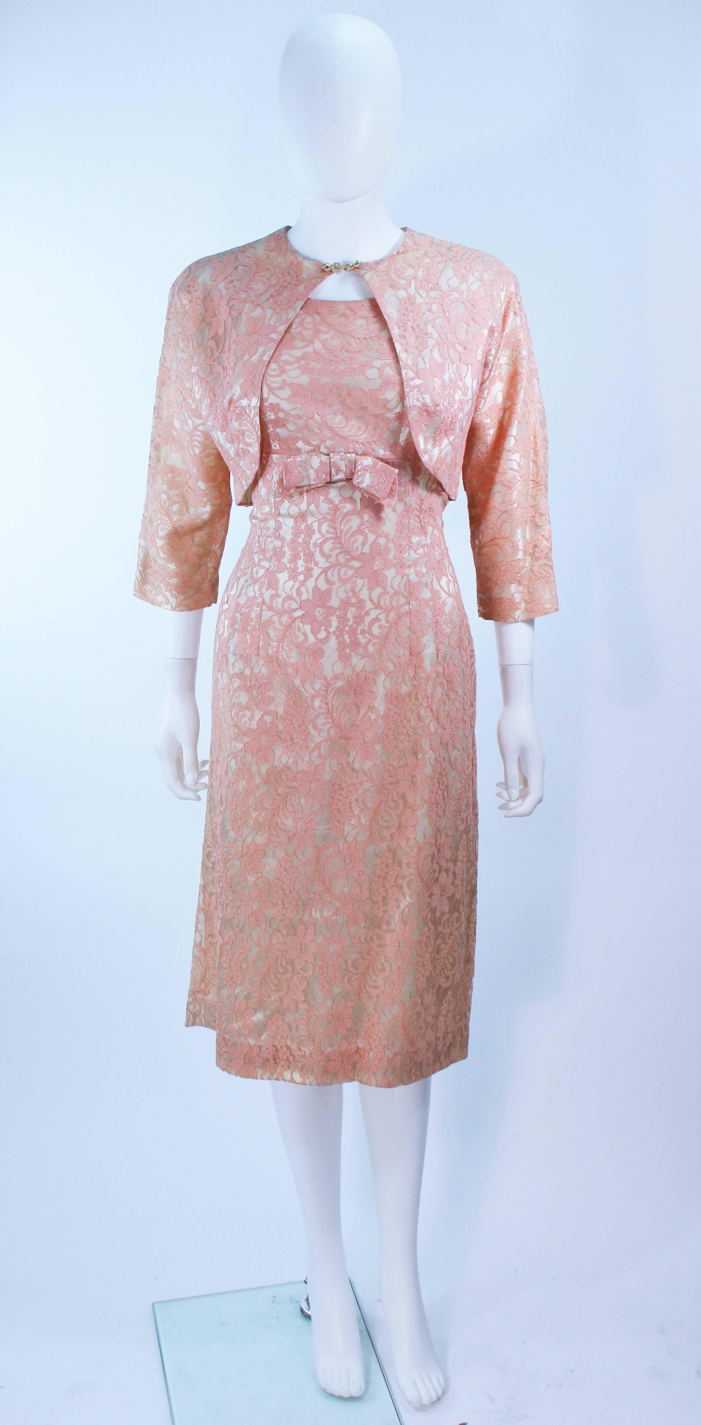  This cocktail dress is composed of a peach hue lace. Features a bow at the center front of the dress, a rhinestone closure on the bolero. There is a center back zipper closure. In great vintage condition.

  **Please cross-reference measurements