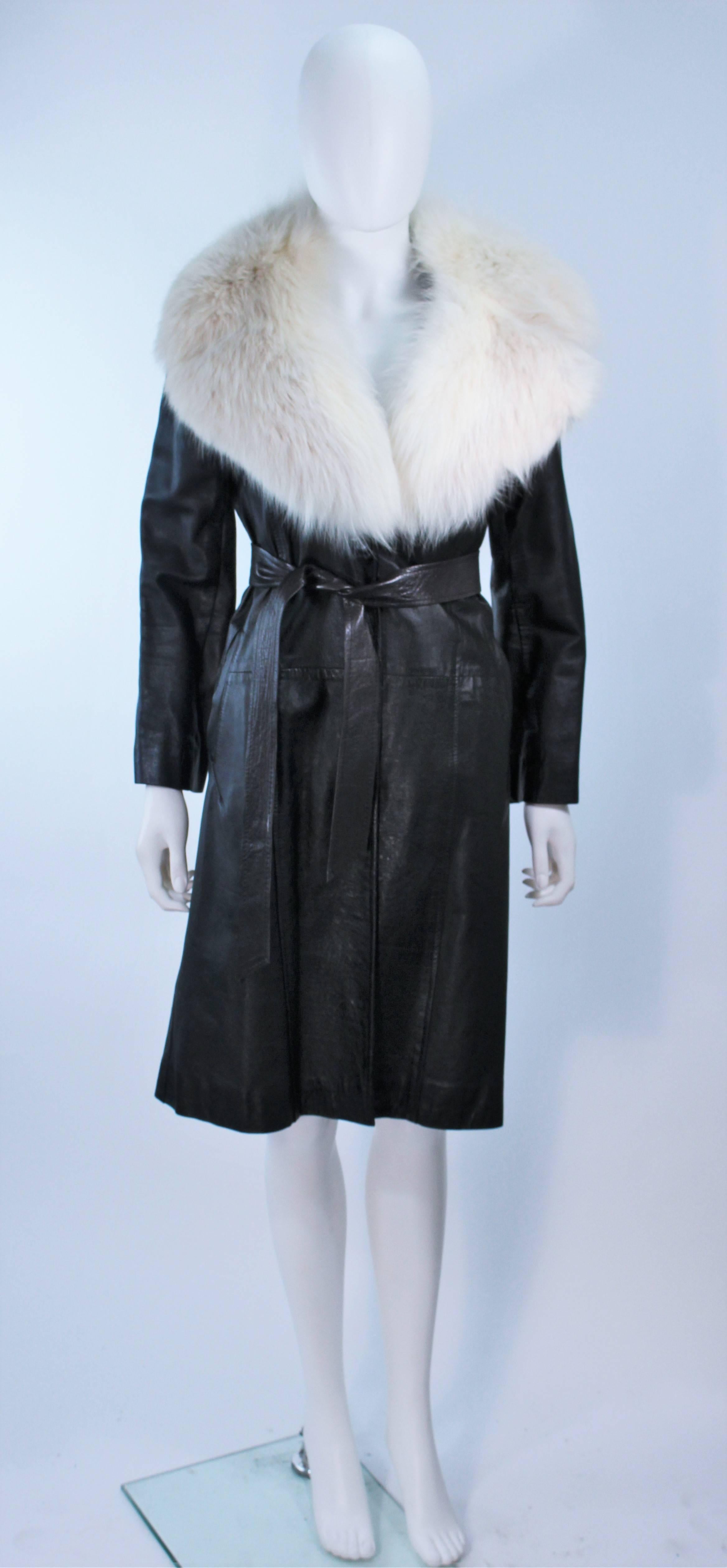  This coat is composed of a black wool with large white fox collar. Features center front button closures with belt and side pockets. Featured in the film 