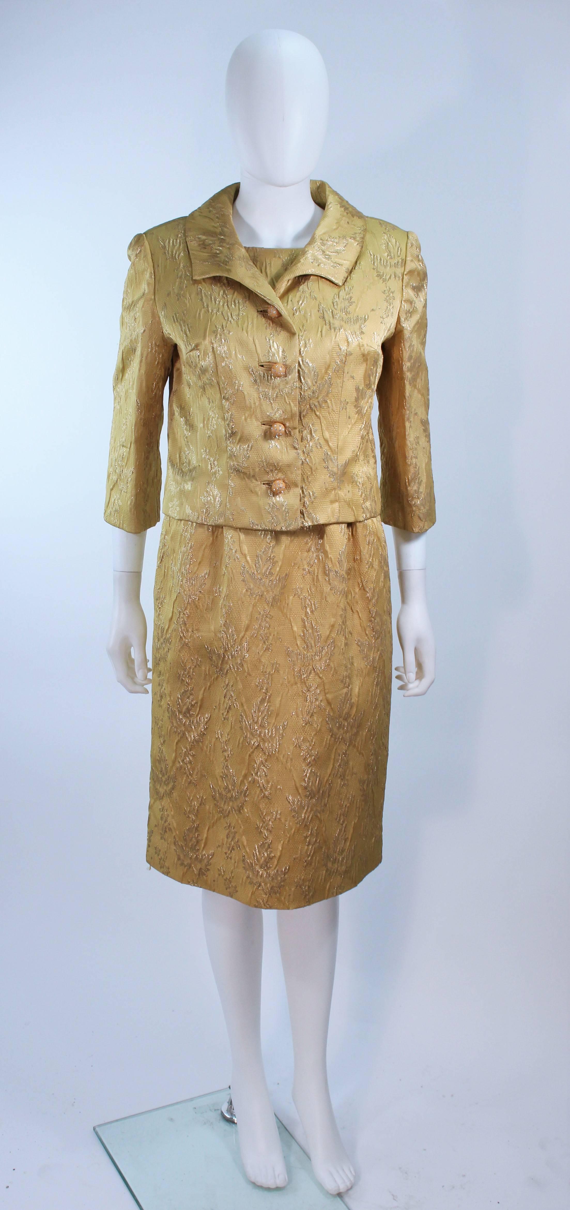 This Andrew Arkon  ensemble is composed of a yellow (mustard hue) brocade with yellow acrylic buttons with rhinestones. The dress has short sleeves with a zipper closure. In great vintage condition, some wear due to age.

  **Please