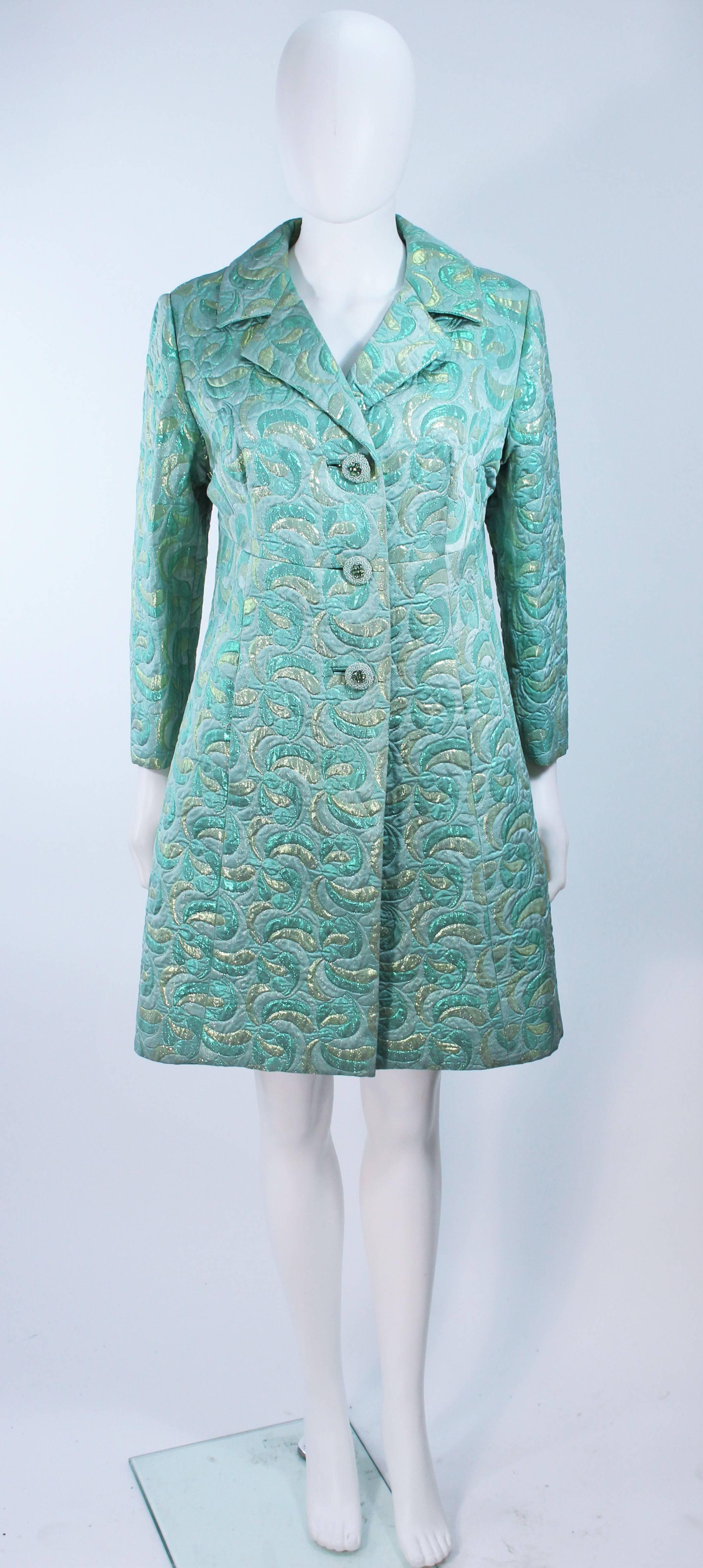  This coat is composed of an aqua metallic brocade. Features beaded buttons at the center front with side pockets. In great vintage condition.

  **Please cross-reference measurements for personal accuracy. Size in description box is an