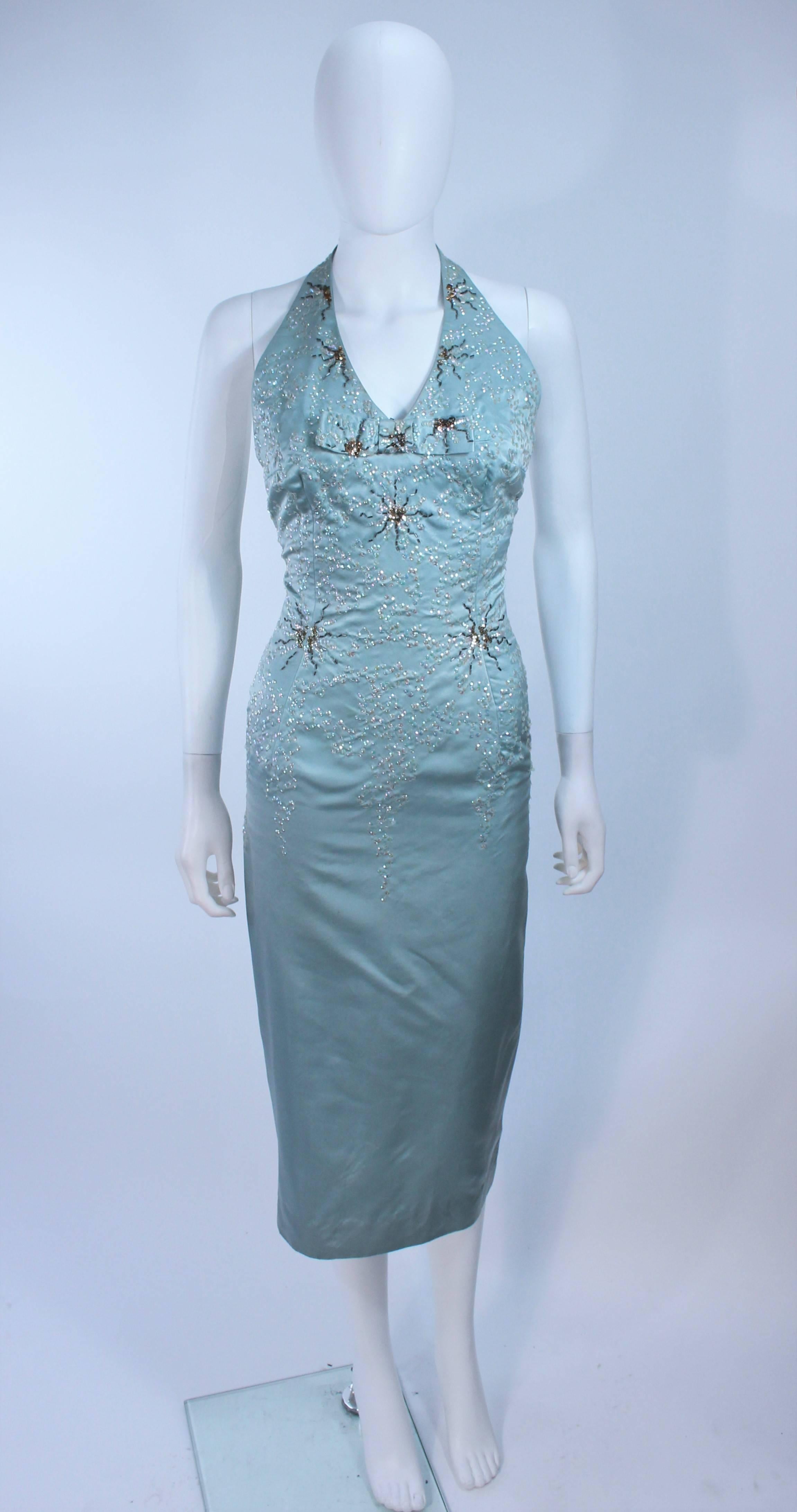  This cocktail dress is composed of an aqua silk with sequin and bead embellishments. There is a center front bow with zipper closure, and halter style. In great vintage condition.

  **Please cross-reference measurements for personal accuracy.