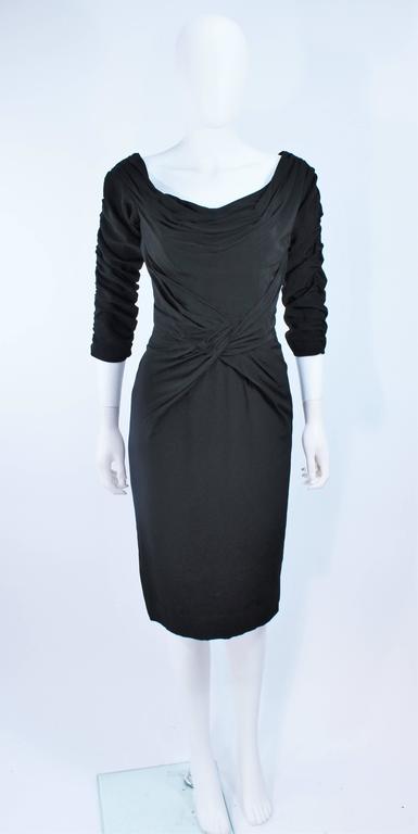 This Ceil Chapman dress is composed of a black crepe. Features darting, gathering, and  rouching throughout with center back zipper. Excellent design.

  **Please cross-reference measurements for personal accuracy. Size in description box is an