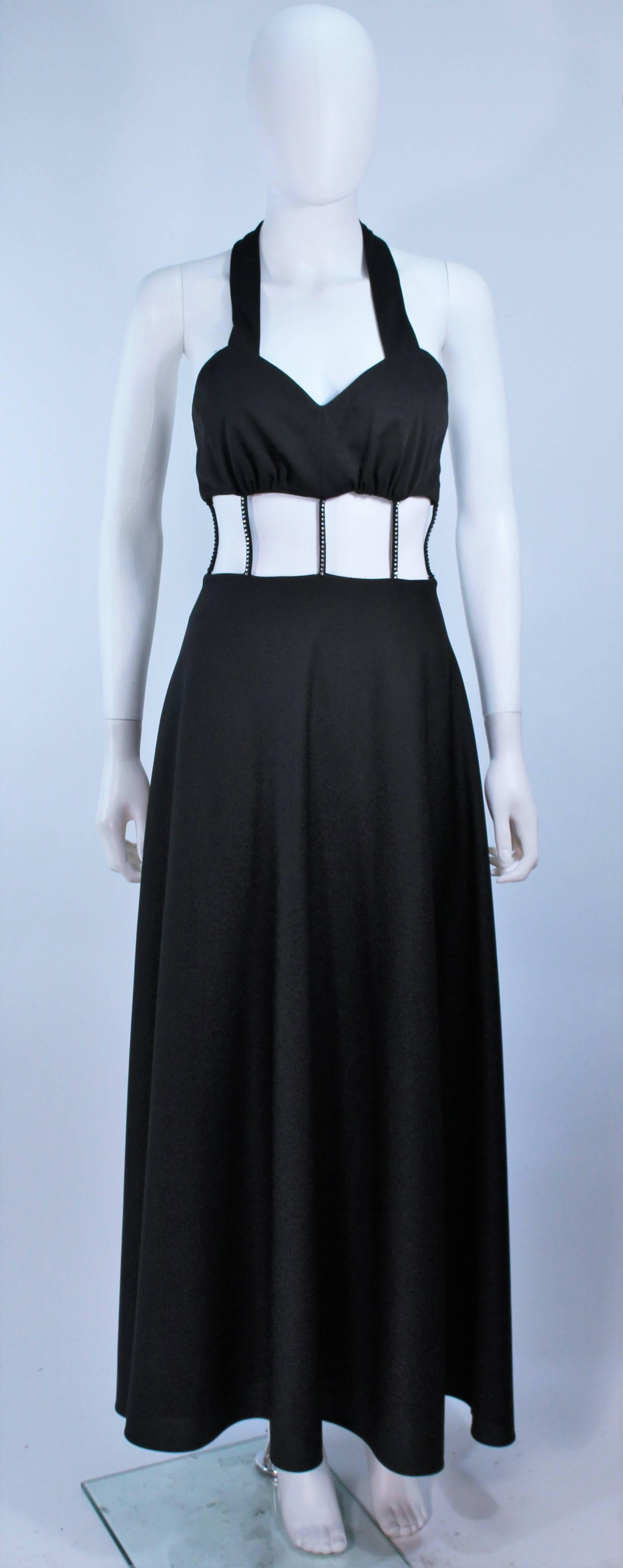  This gown is composed of a black jersey. Features a cutout waist with rhinestone detail. There is a center back zipper closure with buttons. In  excellent vintage condition.

  **Please cross-reference measurements for personal accuracy. Size in