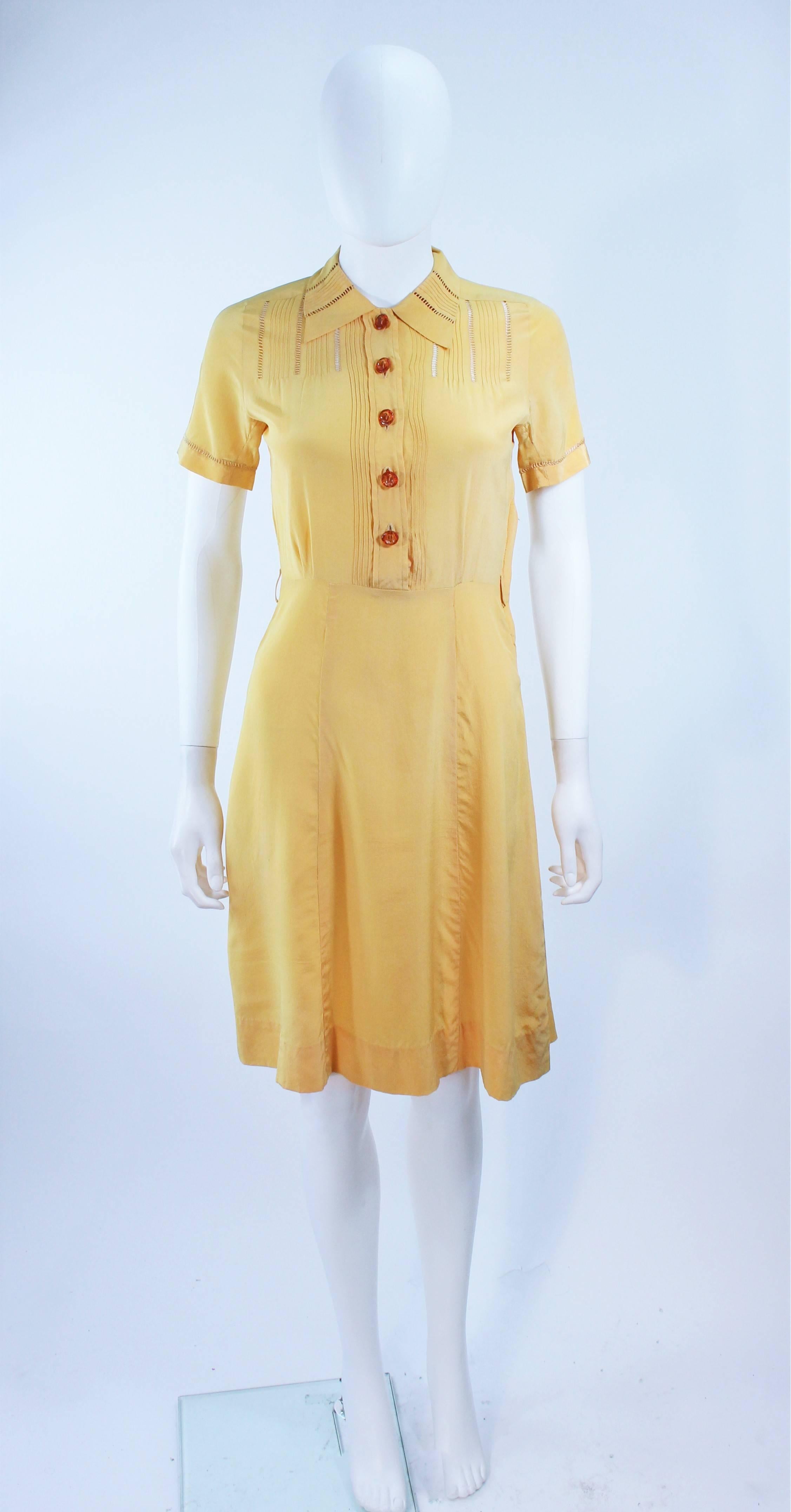 This dress is composed of a yellow hue silk. Features sheer lace inserts, front pockets, and center front buttons. In excellent vintage condition, some slight discoloration due to age.

**Please cross-reference measurements for personal accuracy.