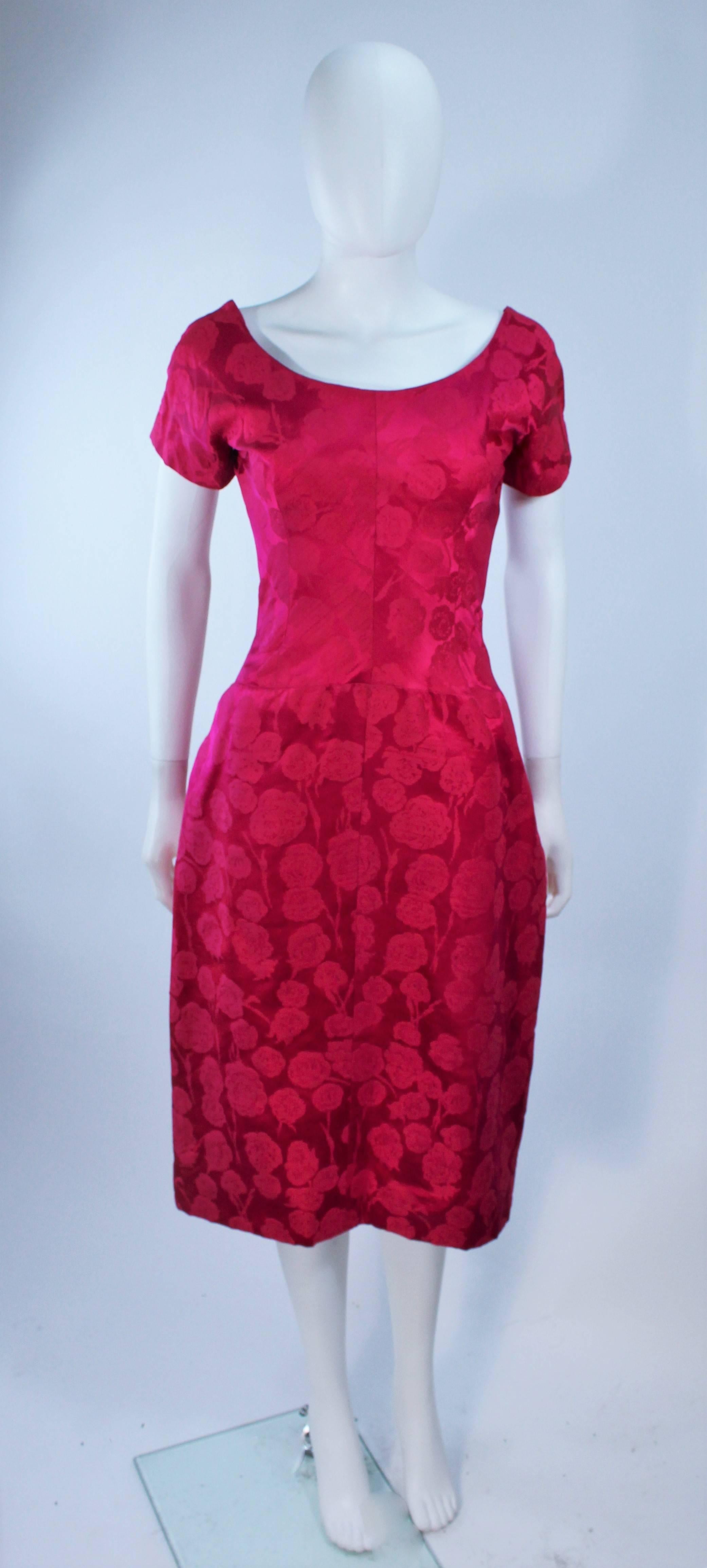 This RARE Schiaparelli attributed cocktail or day dress is composed of a pink silk Damask, with a floral print. 

The Label is missing from this dress and apparently tradectly lost when dry cleaned.

The dress does NOT have a zipper as you can see,