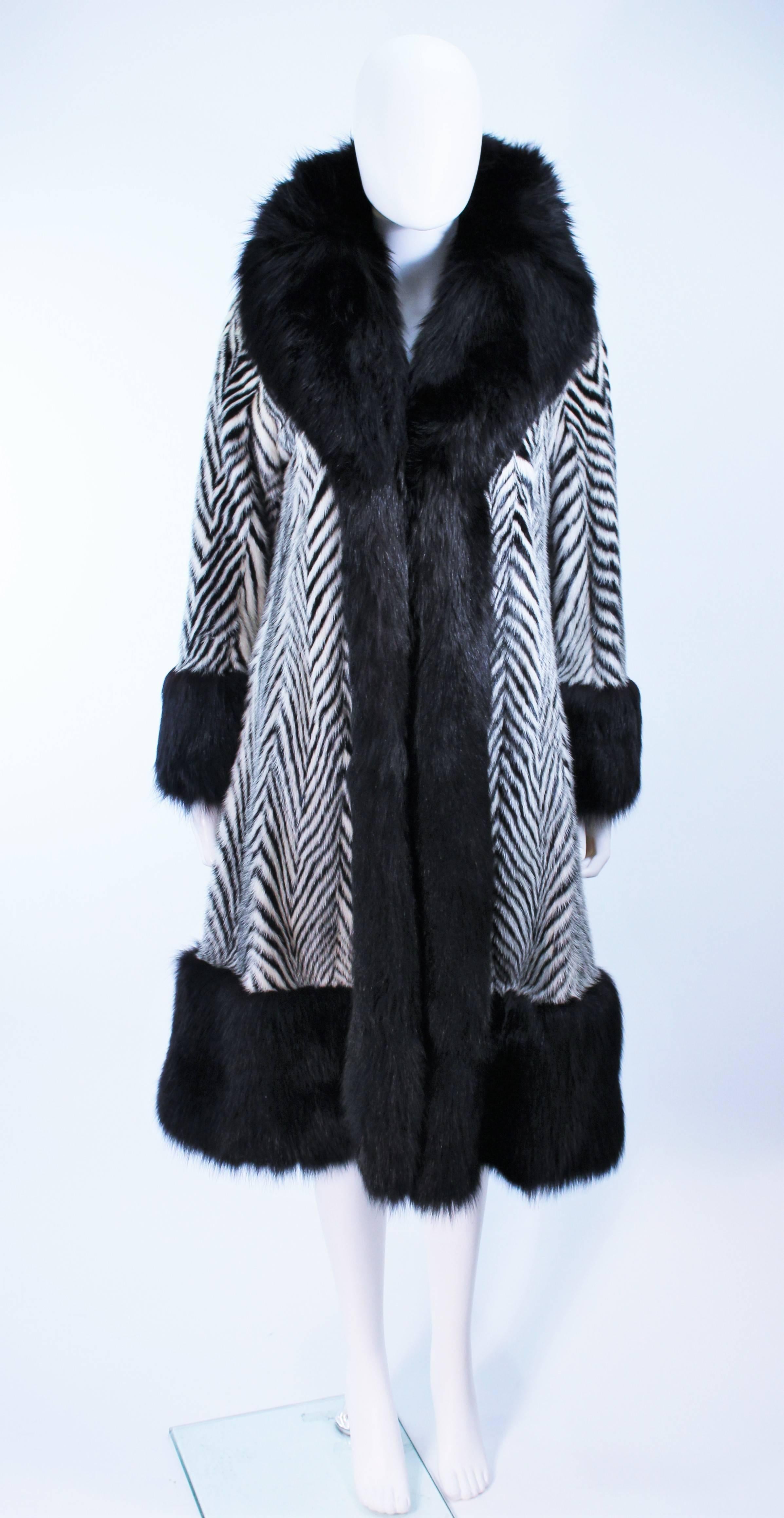 This coat is a custom Zaccaria  of California Fur coat, composed of a black fox collar and cuffs with black and white mink in a stunning chevron pattern.  There are side pockets as well as (3) center front hook and eye closures. Silk lining and