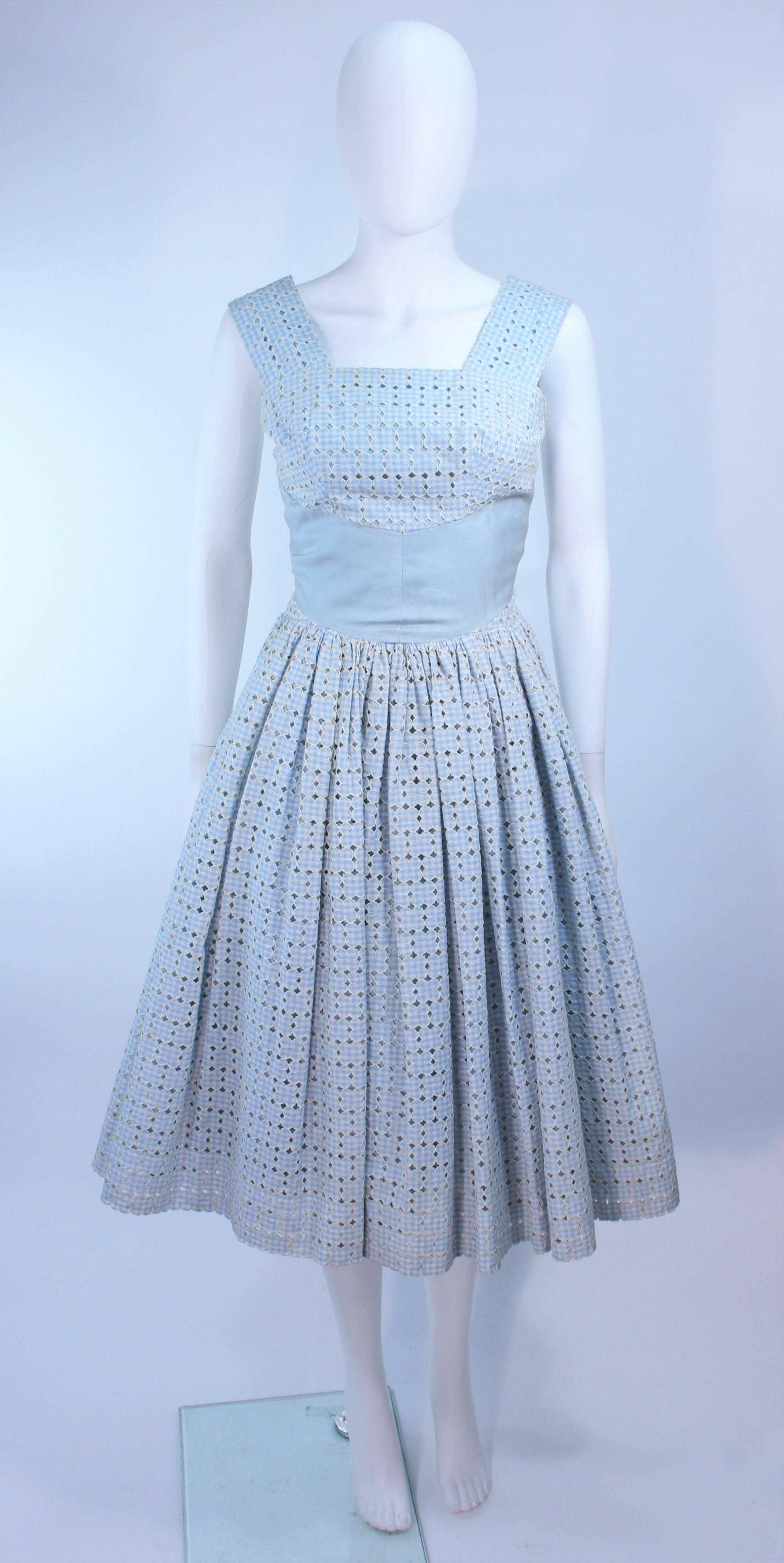This dress is composed of a blue and white eyelet cotton. Features a zipper closure. In excellent condition. Shot with crinoline (not included).

**Please cross-reference measurements for personal accuracy. Size in description box is an