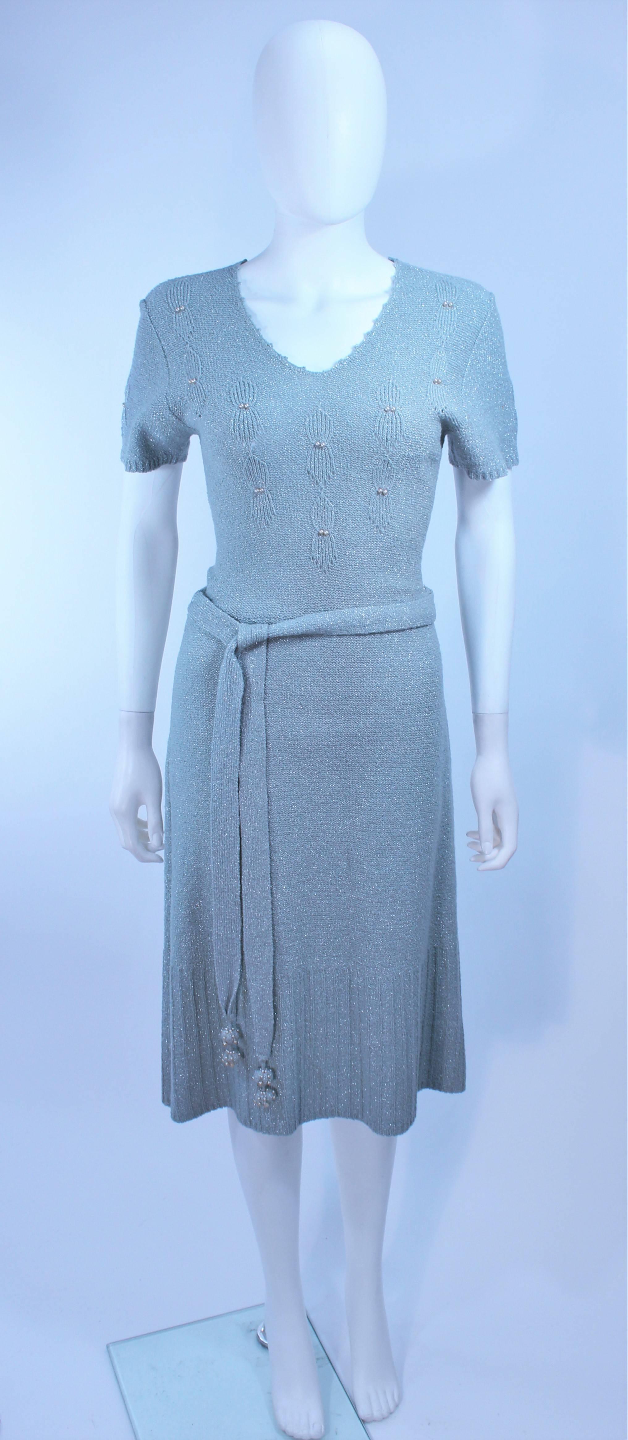 This dress is composed of a blue knit wool with iridescent accents. Features pearl accents and a belt. In excellent vintage condition.

**Please cross-reference measurements for personal accuracy. Size in description box is an