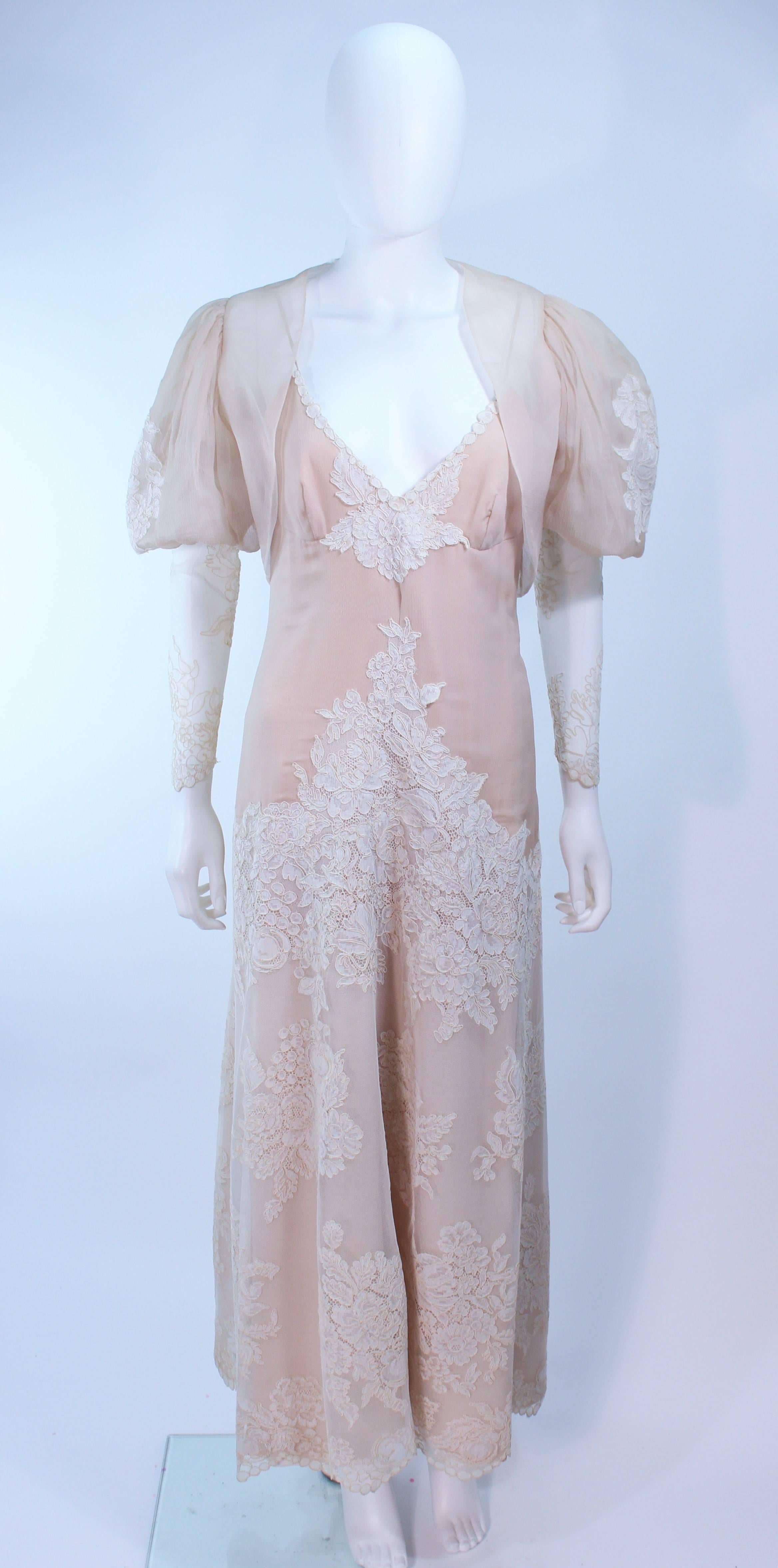 This ensemble is composed of a nude chiffon with white lace. Features separate lace sleeves, a puff sleeve bolero, and gown. The gown features a center back zipper. In excellent vintage condition.

**Please cross-reference measurements for