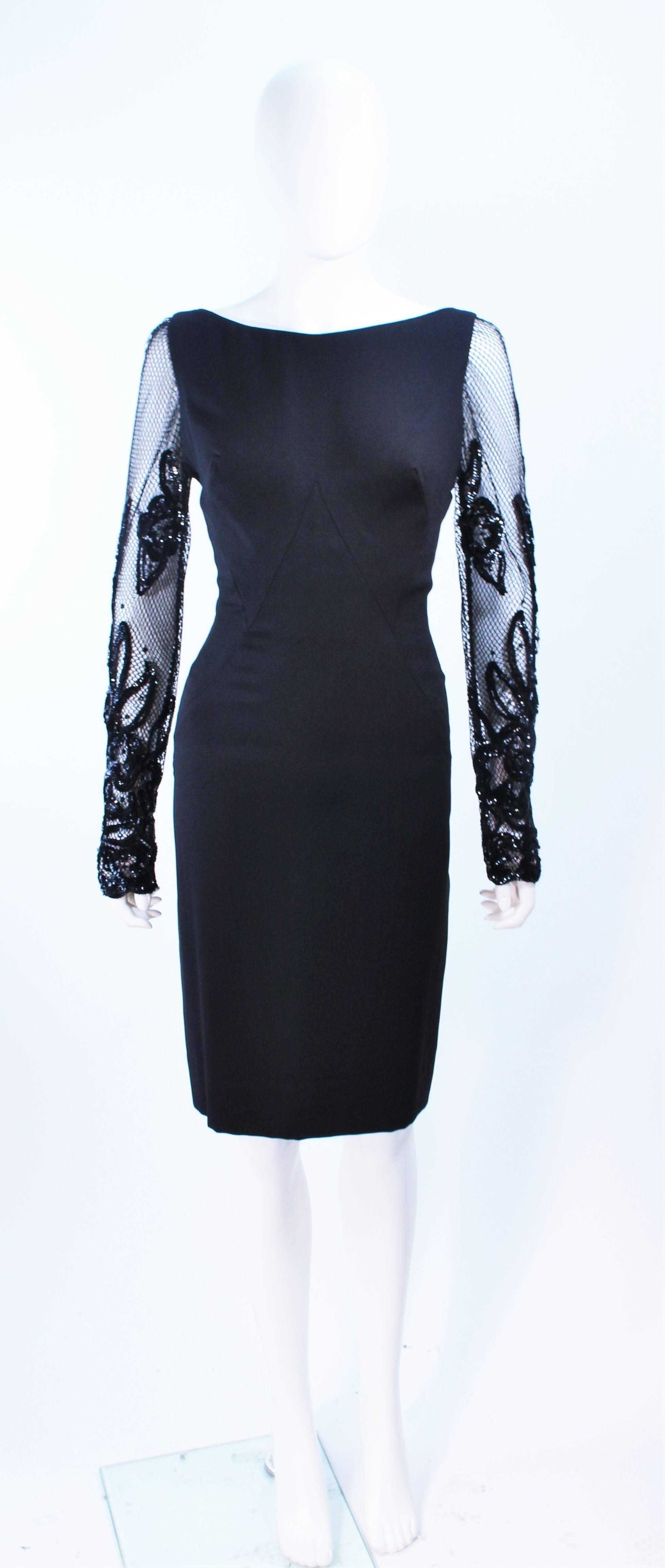 This cocktail dress is composed of a black silk and features mesh sleeves with sequin applique in a floral pattern. There is a center back zipper closure with hook and eye. In excellent vintage condition.

**Please cross-reference measurements for