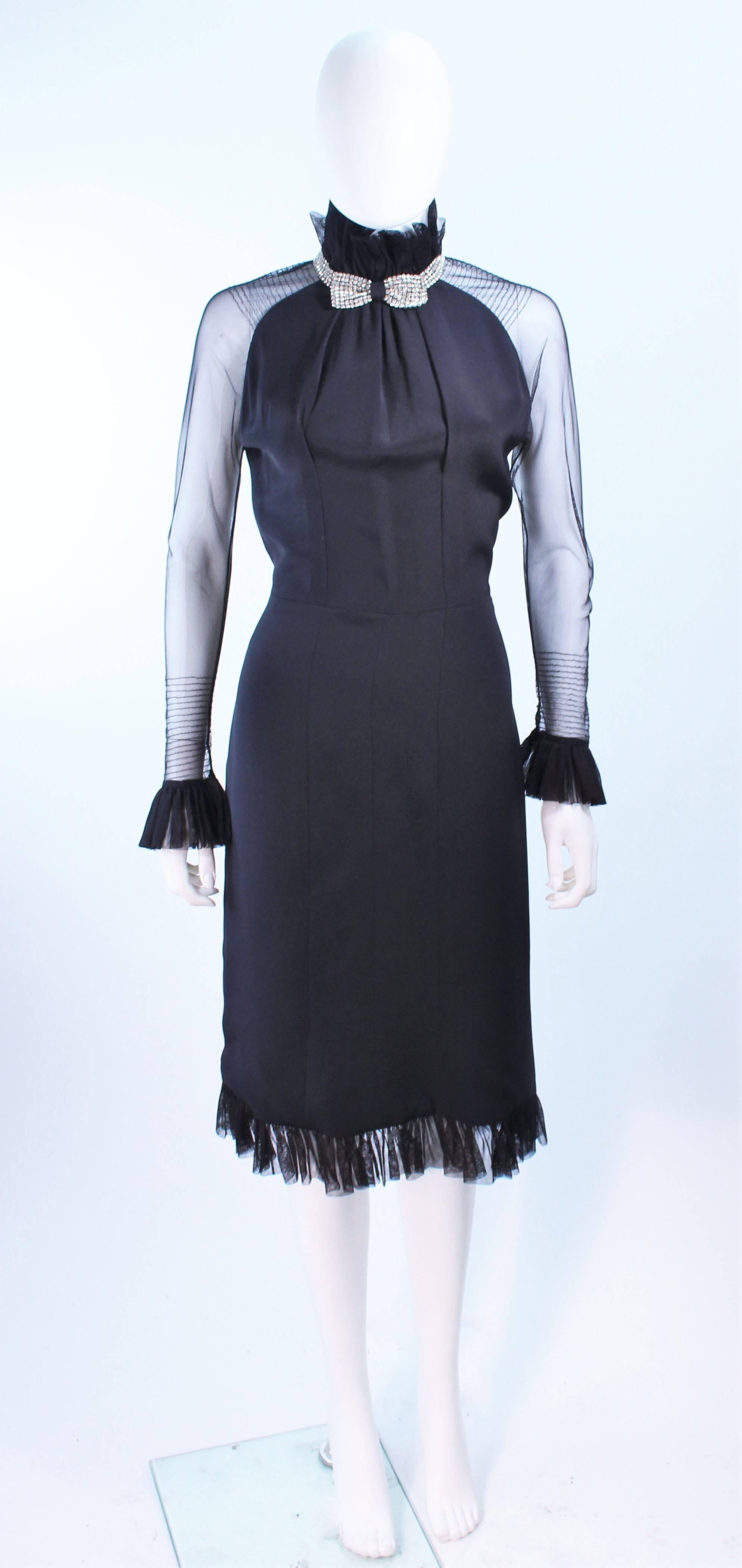 This Lucy De Castenou cocktail dress is composed of a black silk with sheer sleeves. Features ruffled accents and a rhinestone collar. There is a center back zipper. In excellent vintage condition.

**Please cross-reference measurements for