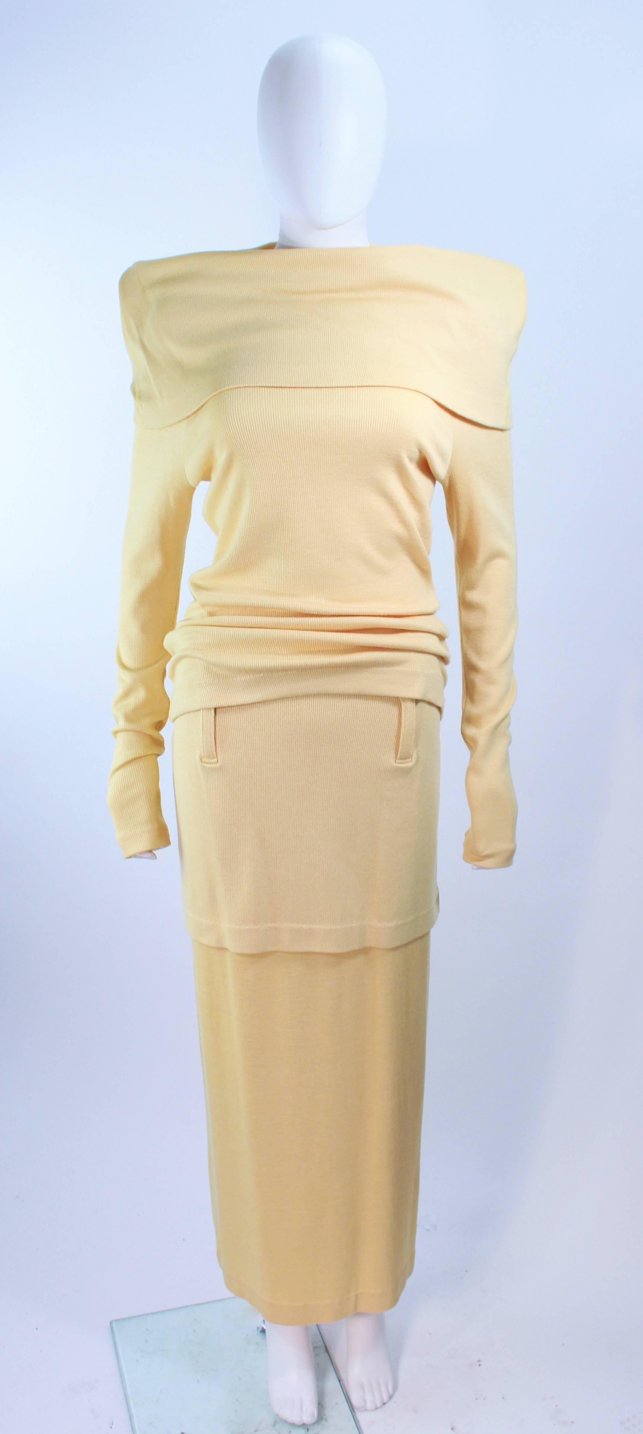 This Issey Miyaki set is composed of a yellow wool. Features a large collar sweater with extra long sleeves which can be style in a variety of ways. The full length skirt features belt loops and a tier like style. In excellent vintage