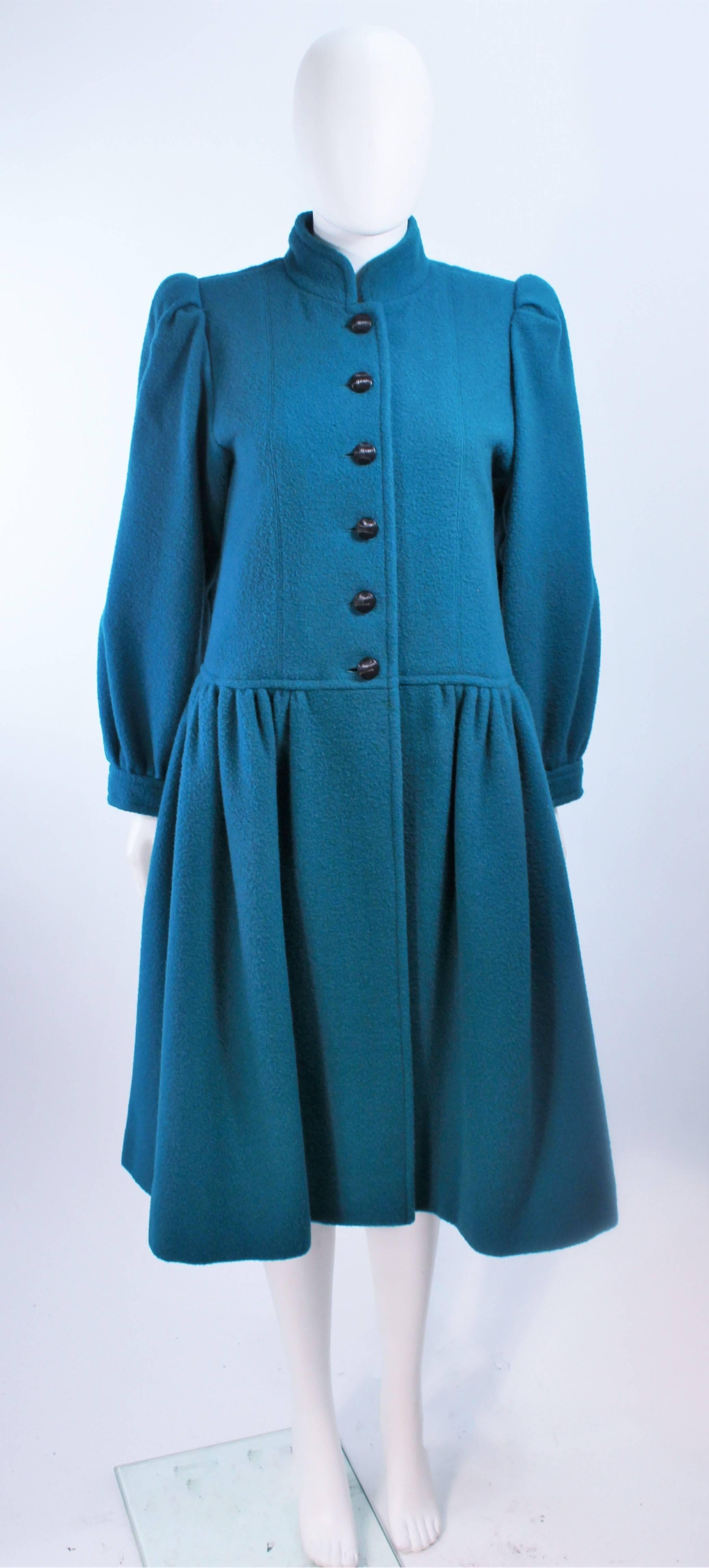 This Yves Saint Laurent design is composed of a turquoise wool. Features a gathered sleeve and center front button closures. In excellent vintage condition.

**Please cross-reference measurements for personal accuracy. Size in description box is