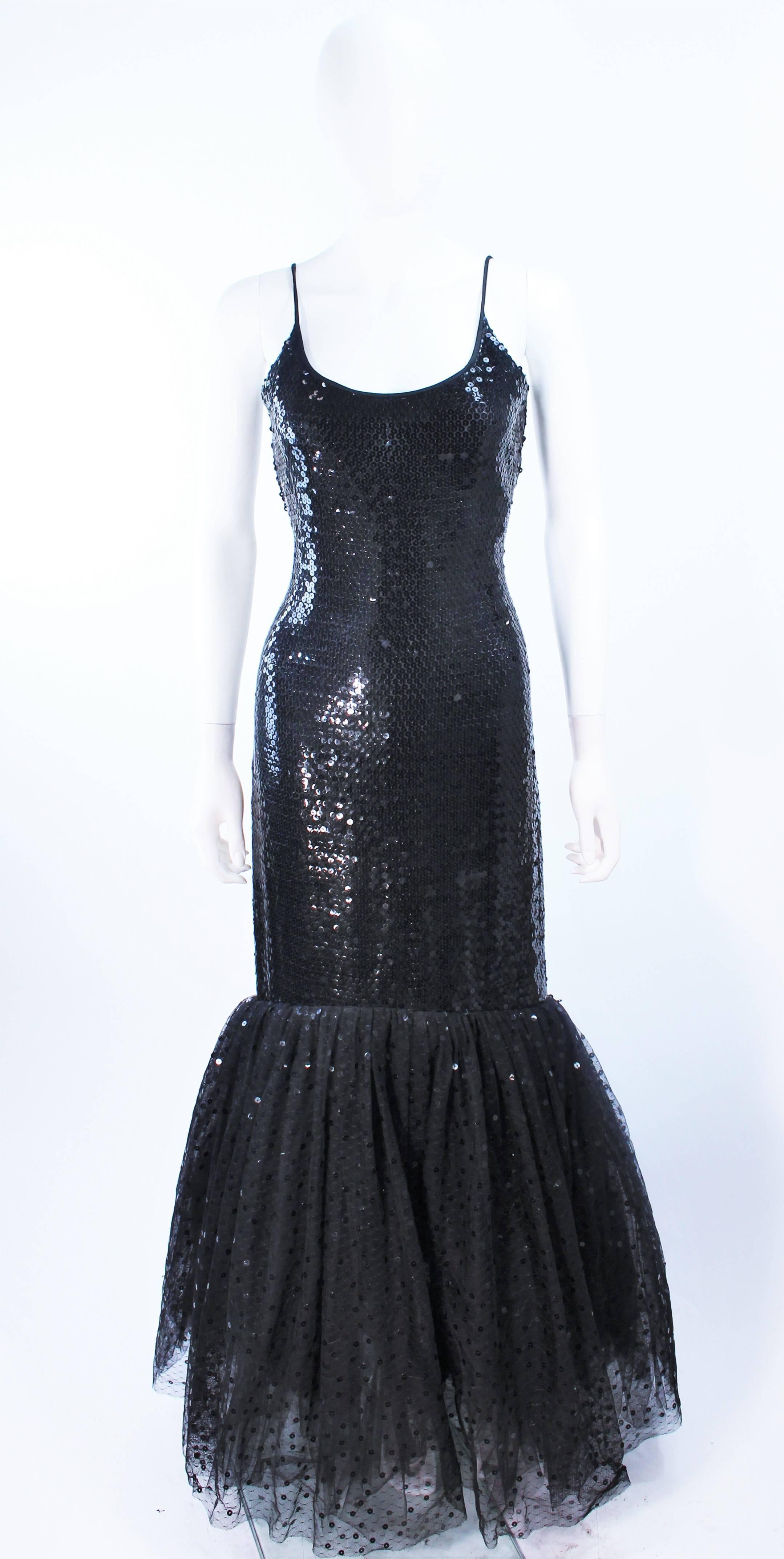 Este vestido de Jill Richards está compuesto por un tejido negro adornado con lentejuelas y un dobladillo acampanado de tul, con un aplique de lentejuelas. Tiene un cierre de cremallera central en la espalda. En excelente estado vintage.

**Por