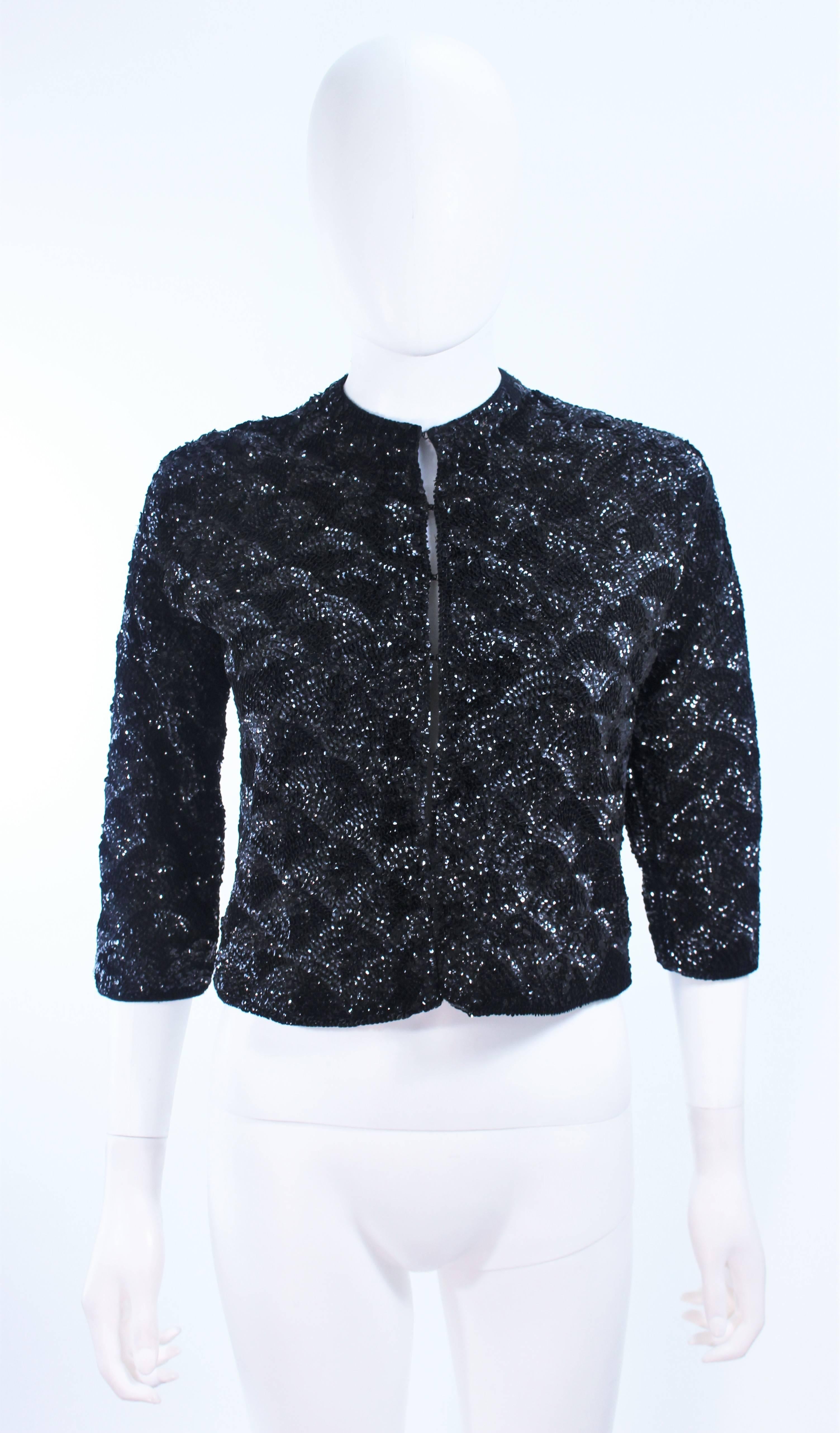 This cardigan is composed of a knit wool with black sequin embellishment in  a fan pattern. There are center front faceted black and gold buttons. In excellent vintage condition.

**Please cross-reference measurements for personal accuracy. Size