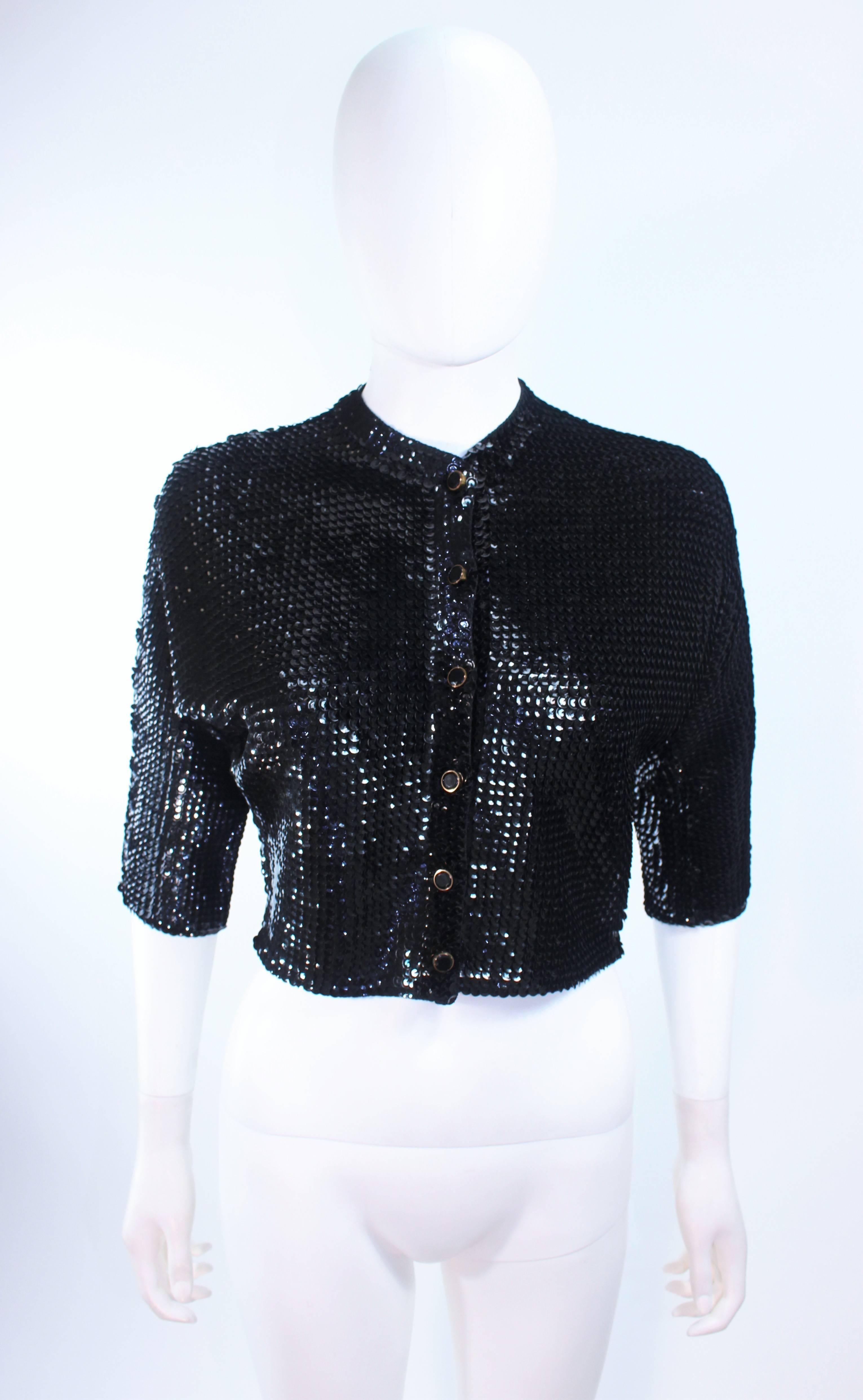 This vintage cardigan is composed of a black sequin wool. There are center front black and gold faceted buttons. In excellent vintage condition.

**Please cross-reference measurements for personal accuracy. Size in description box is an
