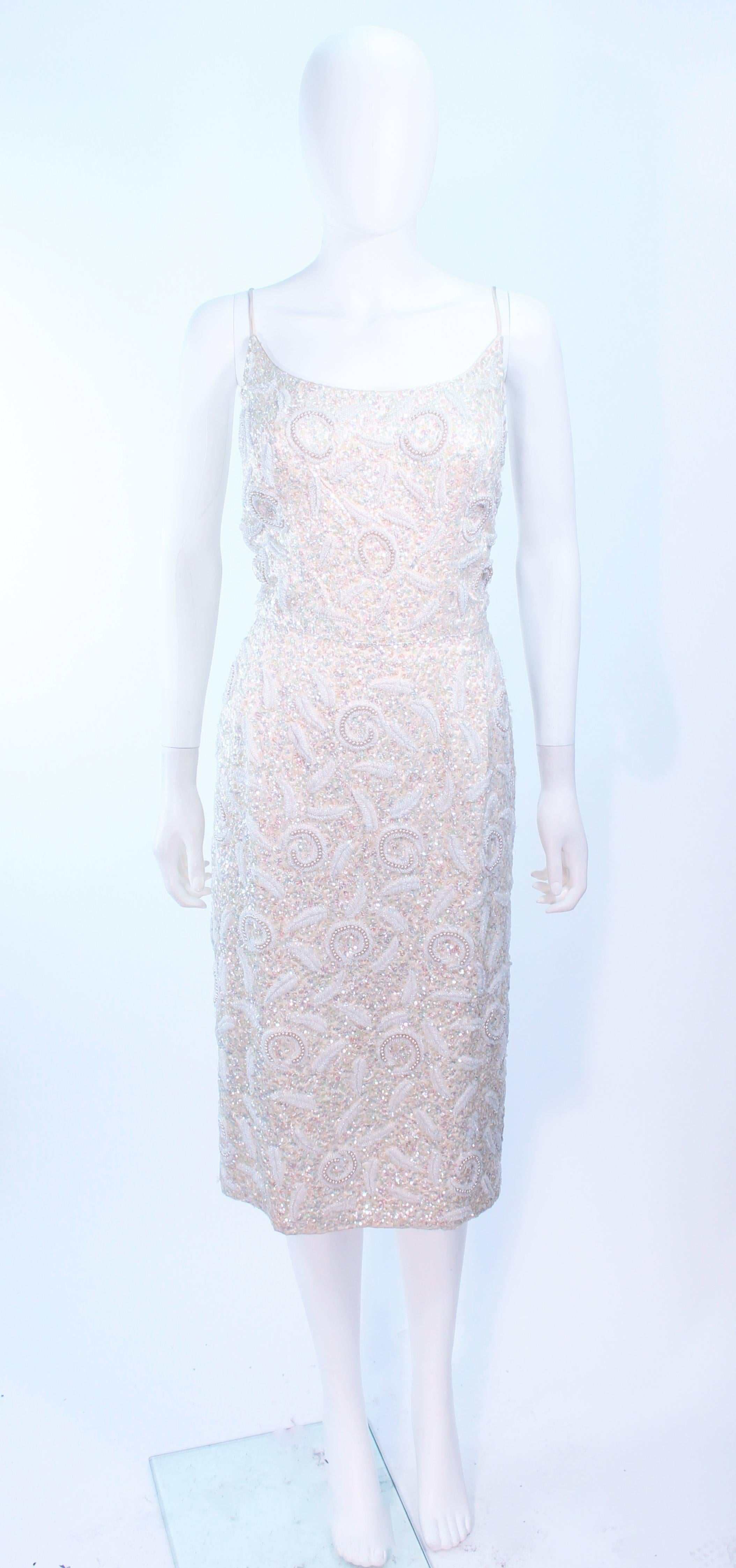 This Haute Couture International cocktail dress is composed of an off white silk with iridescent sequin applique in a floral motif. There is a center back zipper closure. In excellent vintage condition.

**Please cross-reference measurements for