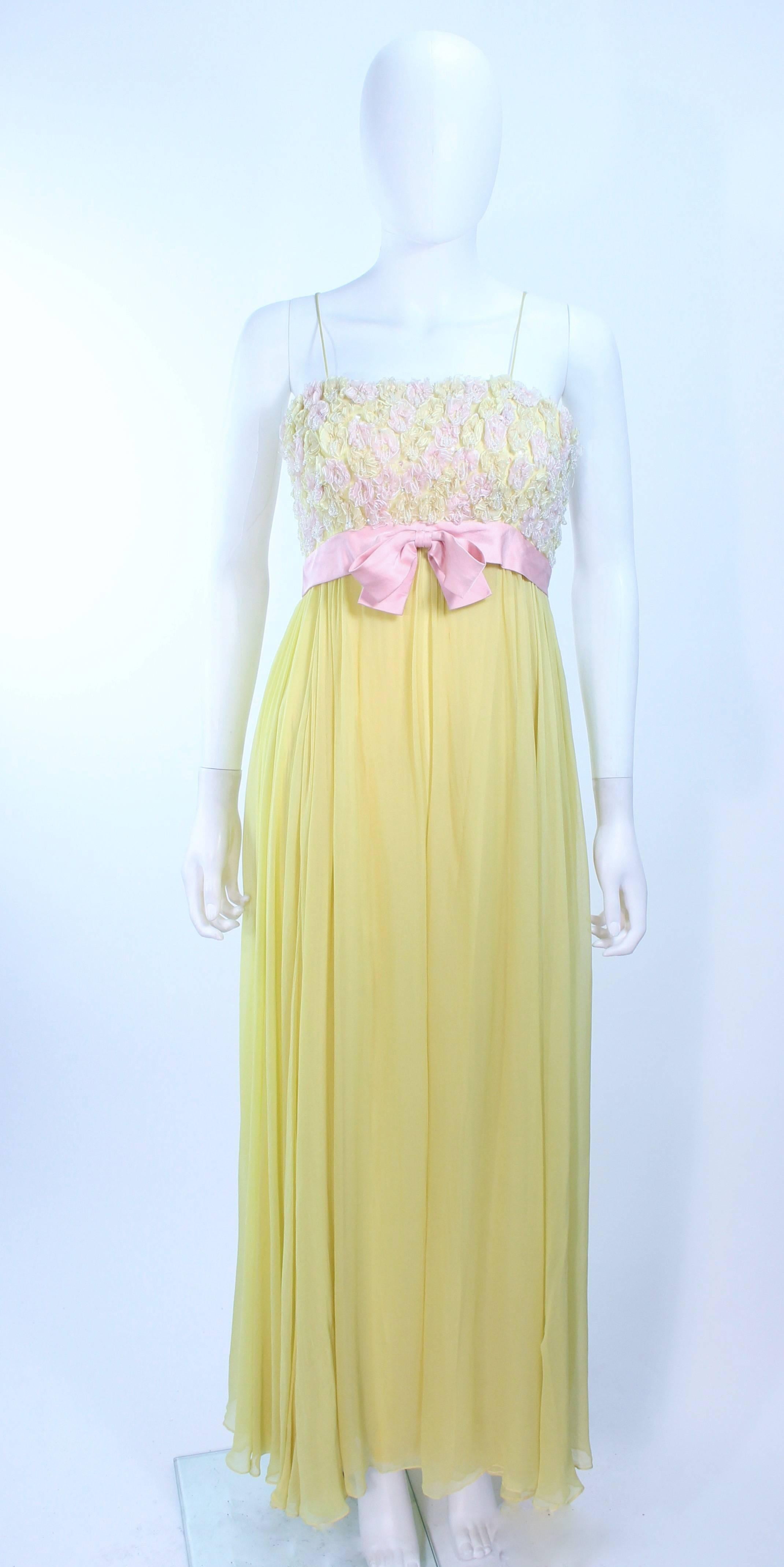Dieses Kleid von Victoria Royal besteht aus gelbem Seidenchiffon mit rosa Blumenapplikationen und Strasssteinen. Es gibt einen Reißverschluss in der Mitte des Rückens. In ausgezeichnetem Vintage-Zustand, eine kleine Flickstelle am Rock, kaum