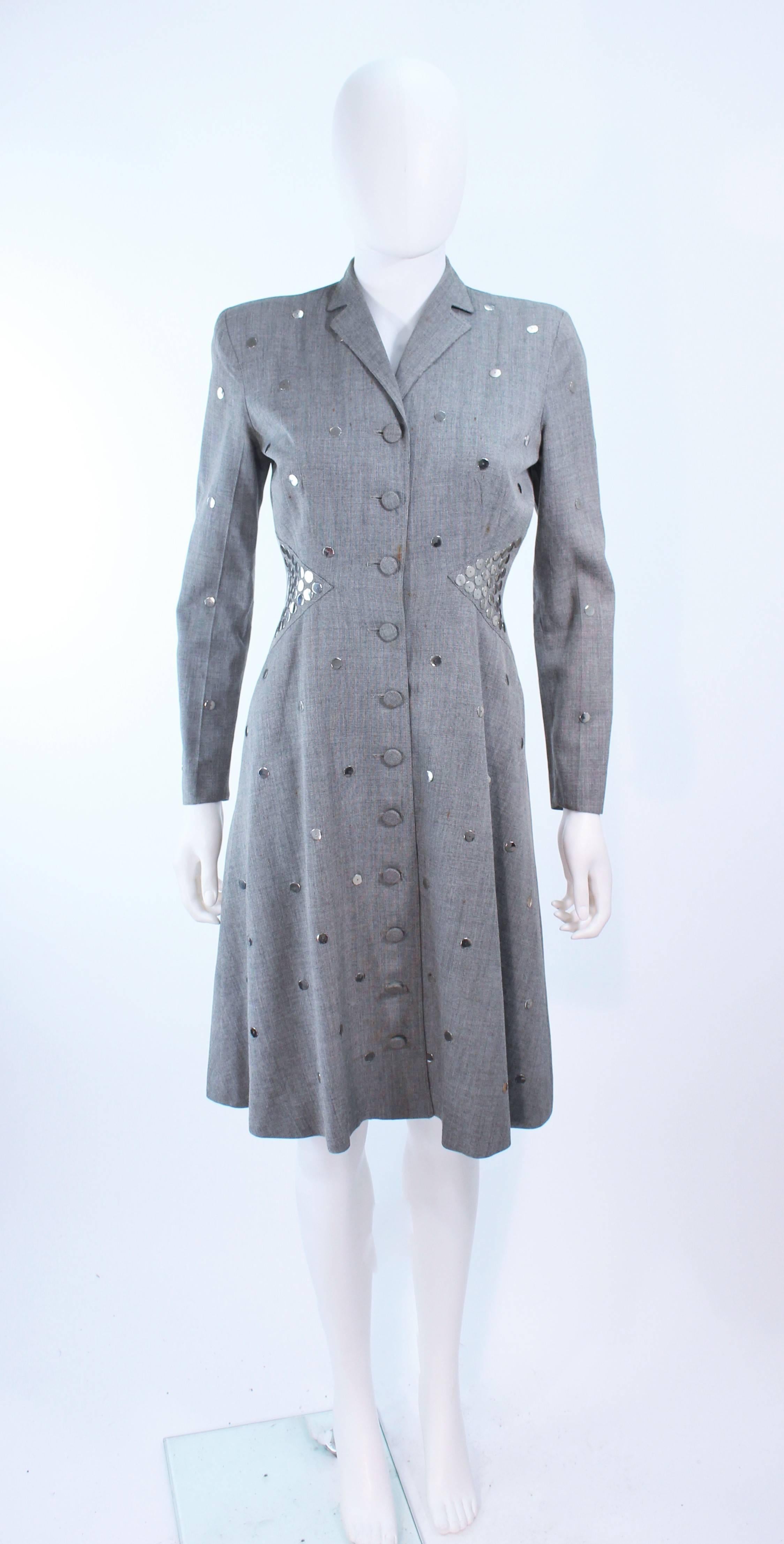 This Kay Collier design is composed of a grey printed wool with metal sequin applique. There are center front button closures. In vintage condition sold 