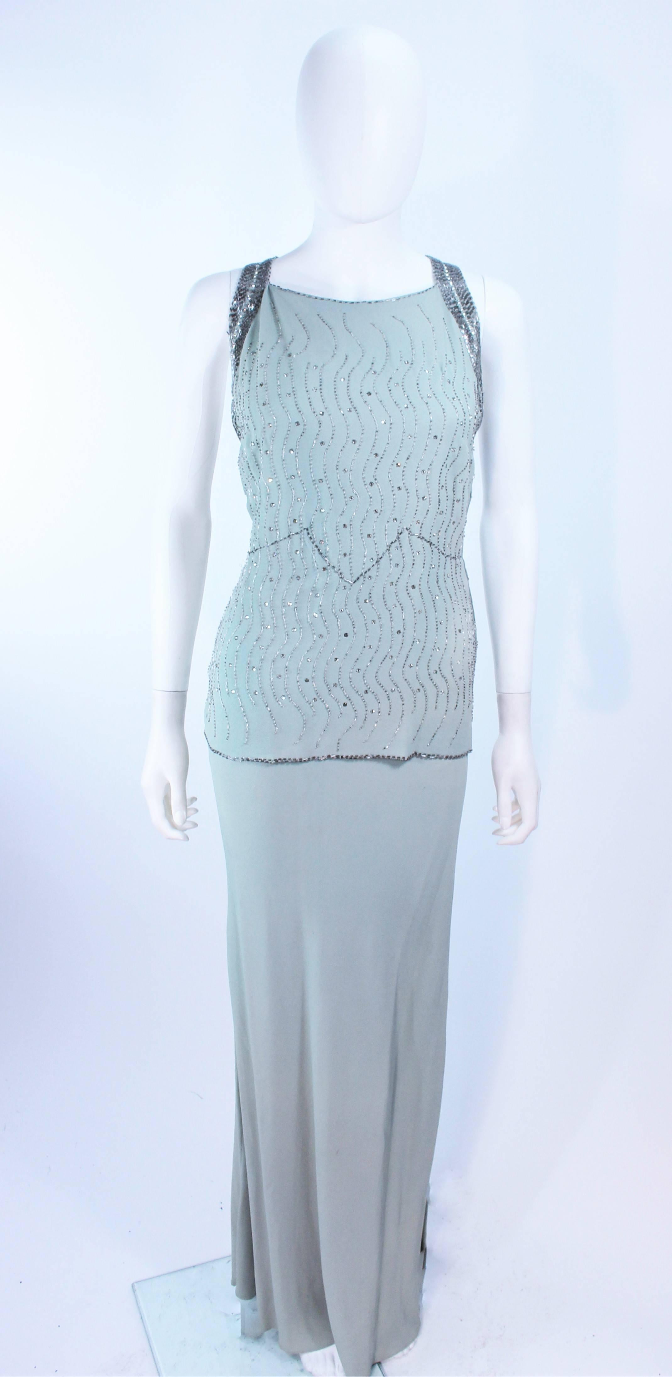 This vintage 1930's gown is composed of a bias cut aqua silk crepe. Features rhinestone and beaded applique throughout. There are side snap closures. In excellent vintage condition, there is discoloration due to age throughout (see photos). Due to