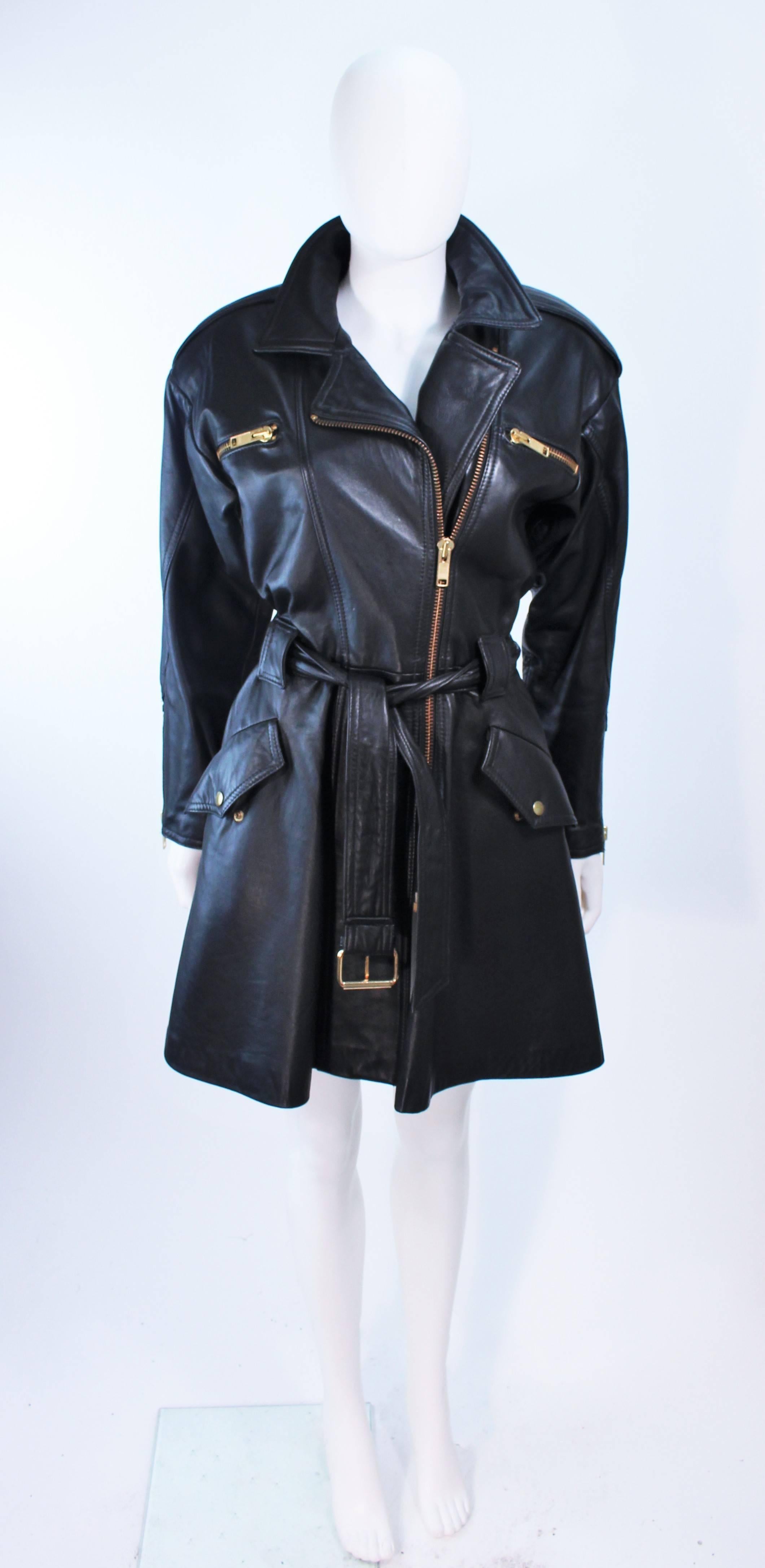 This Margret Godfrey coat is composed of black leather with gold hue metal hardware. Features a dress style design with larger padded shoulders. In excellent vintage condition.

**Please cross-reference measurements for personal accuracy. Size in