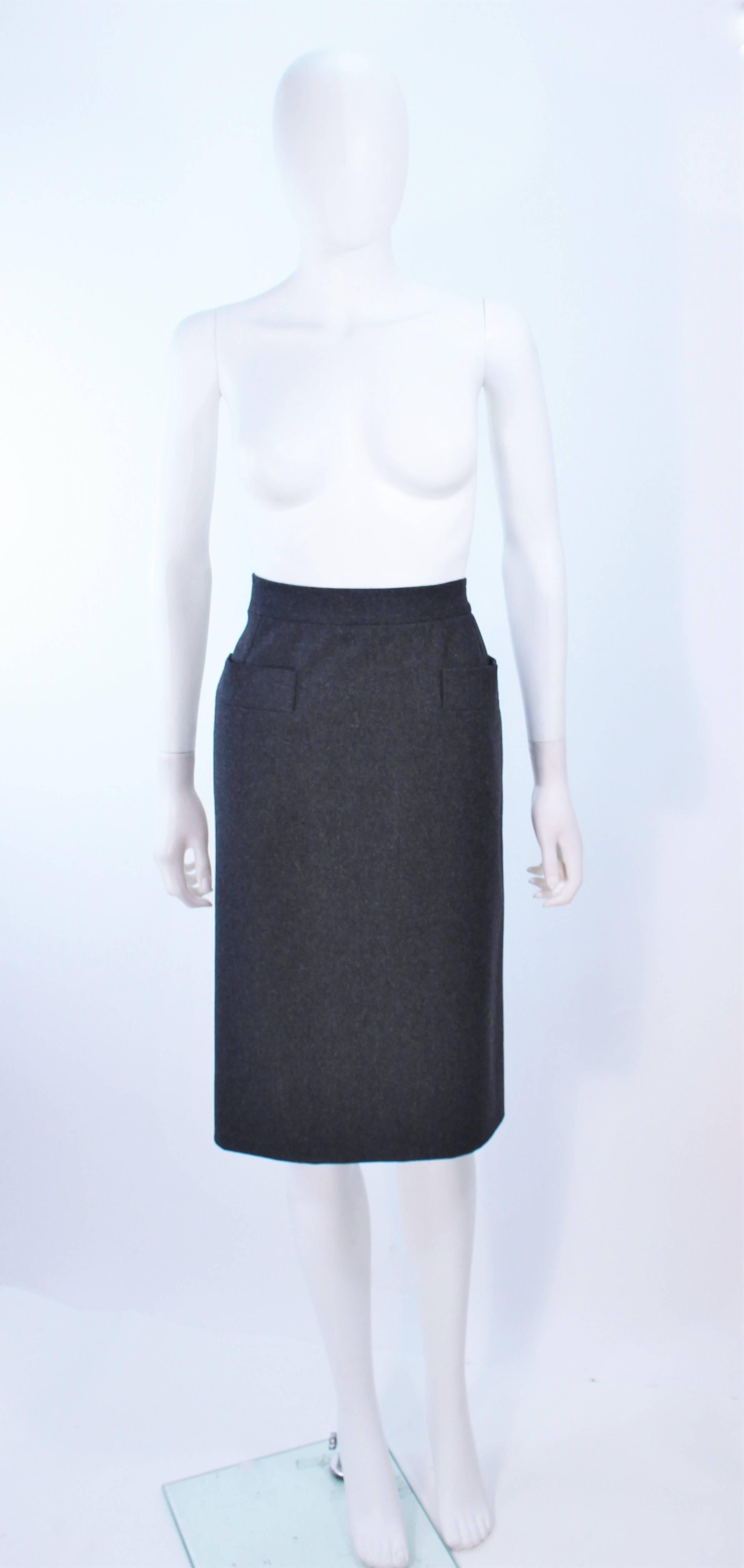 This Yves Saint Laurent skirt is composed of a charcoal wool. Features a pencil  silhouette with front pocket applique. There is a zipper closure. In excellent vintage condition.

**Please cross-reference measurements for personal accuracy. Size