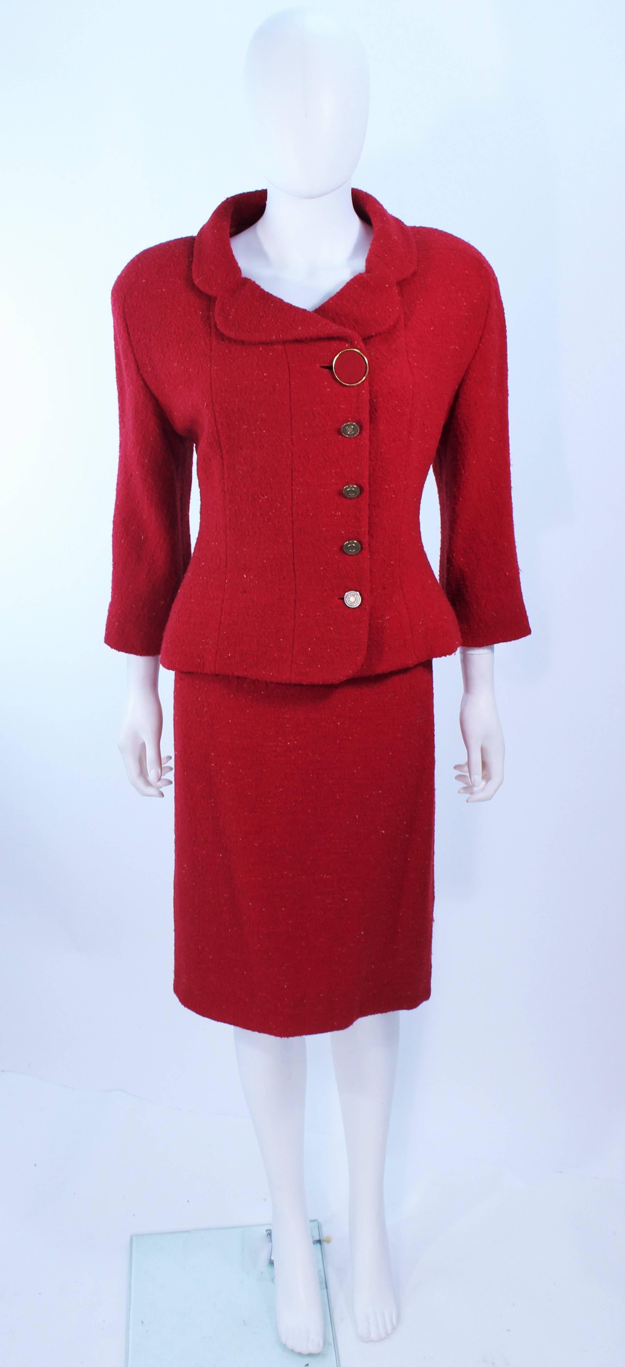 This Karl Lagerfeld suit is composed of a red boucle. The jacket features a large collar with center front button closures and a double breasted style. The skirt has a classic pencil style with a zipper closure. In excellent vintage