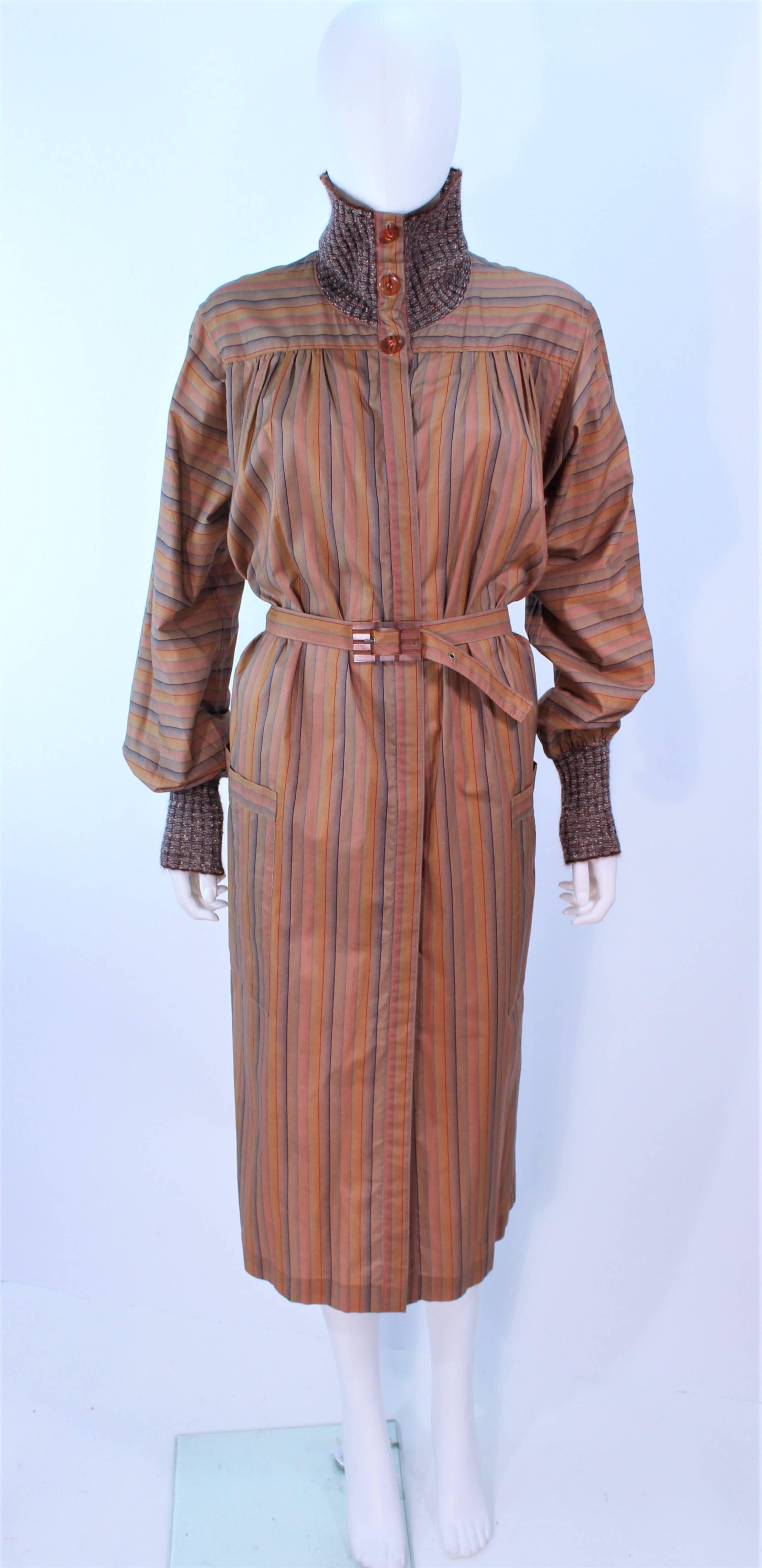 This Missoni design is composed of a striped khaki hue woven fabric with knit trim. Features center front button closures with a waist belt. There are side pockets. In great vintage condition, there is some staining on the front of the coat (see