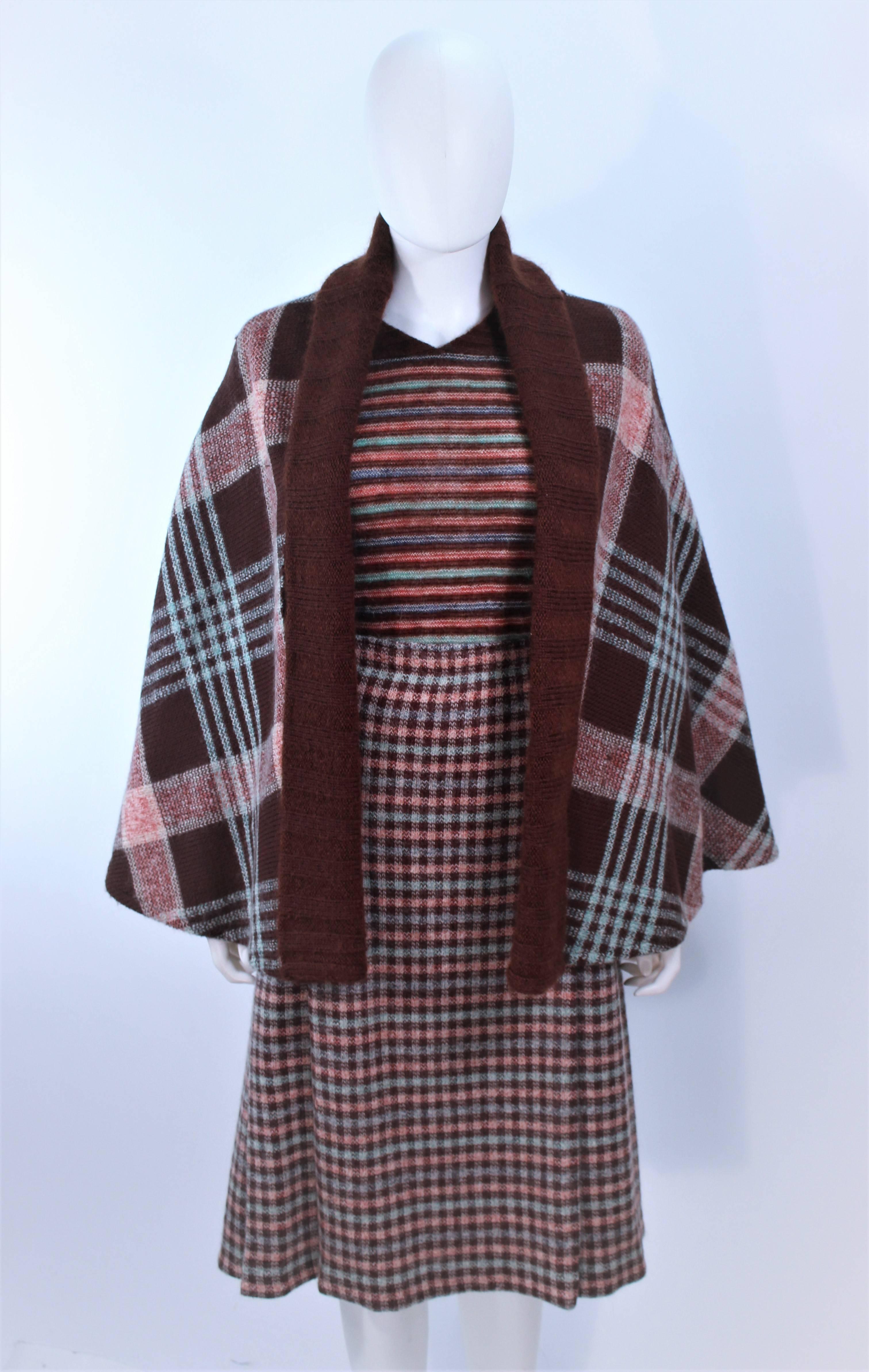 This Missoni design is composed of wool in a brown plaid and stripe. Features a reversible cape, sweater, and plaid skirt with pleats. The skirt has side pockets. In excellent vintage condition.

**Please cross-reference measurements for personal
