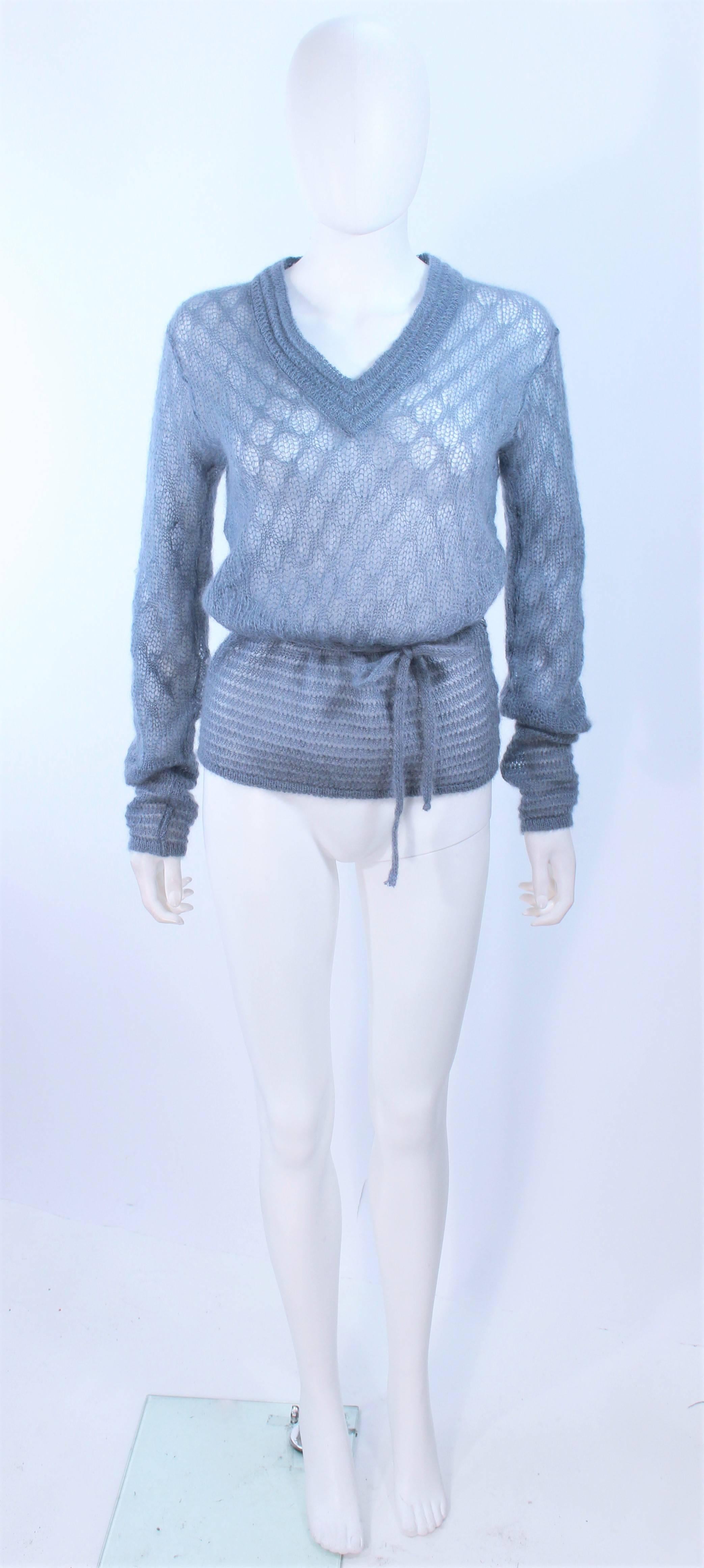 This Missoni design is composed of a sky blue wool with a semi sheer knit property. Features a v-neck with waist tie. In excellent vintage condition.

**Please cross-reference measurements for personal accuracy. Size in description box is an